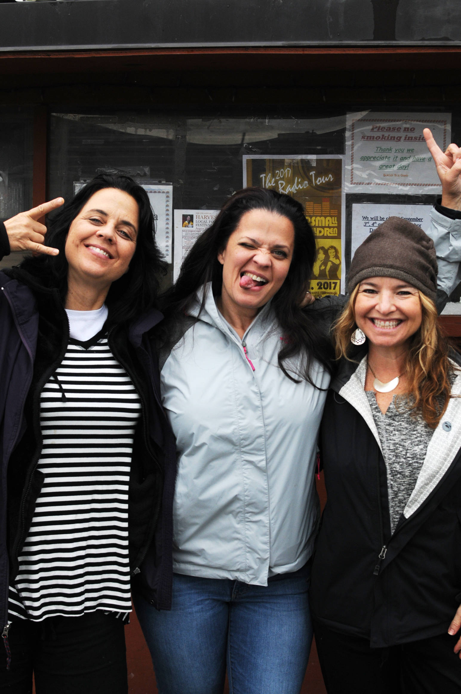 (From left) Lisa Pimentel, Joanie Pimentel and Nicola Berlinsky, the three members of Los Angeles-based rock outfit No Small Children, pose for a photo near the Burger Bus restaurant on Thursday, Aug. 31, 2017 in Kenai, Alaska. The three will perform at an assembly at Nikiski Middle-High School on Friday afternoon, followd by a show at 7 p.m. at the Triumvirate Theatre in North Kenai and another show at Alice’s Champagne Palace in Homer on Saturday. (Photo by Elizabeth Earl/Peninsula Clarion)