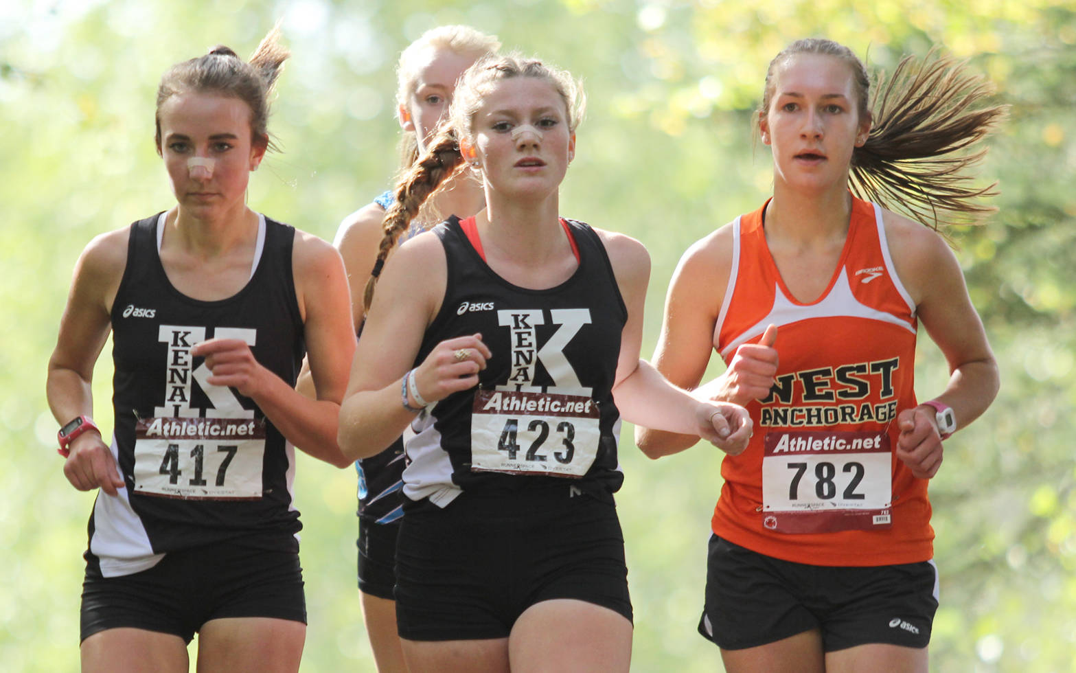 Kenai Central’s Riana Boonstra and Addison Gibson keep pace with West Anchorage’s Victoria Mayer during the second lap of the five-kilometer girls varsity race of the Palmer Invitational Saturday, Sept. 2, 2017, on the Michael Janecek Trails at Palmer High School. Gibson edged Boonstra at the finish line, and the Kardinals placed fifth and sixth in the field. (Photo by Jeremiah Bartz/Frontiersman)