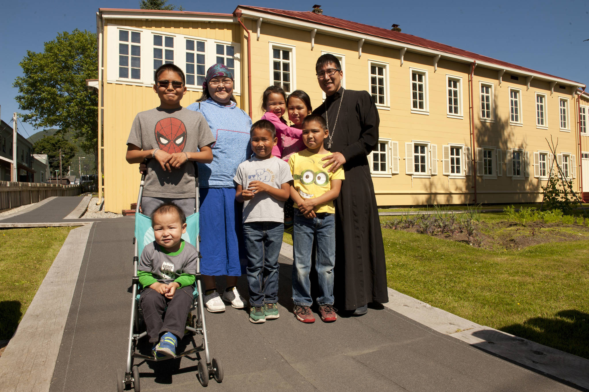 In an Aug. 4 photo, Father Ishmael Andrew, right, the new priest at St. Michael’s Orthodox Cathedral, and his family pose outside the Russian Bishop’s House in Sitka.(James Poulson/Daily Sitka Sentienl via AP)