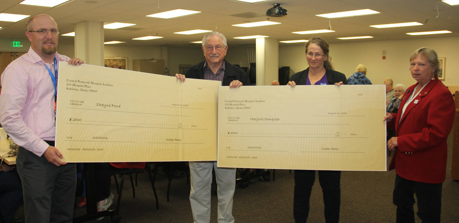 Shayne Pond and Marjorie Dempster receive big checks from the Central Peninsula Hospital Auxiliary.