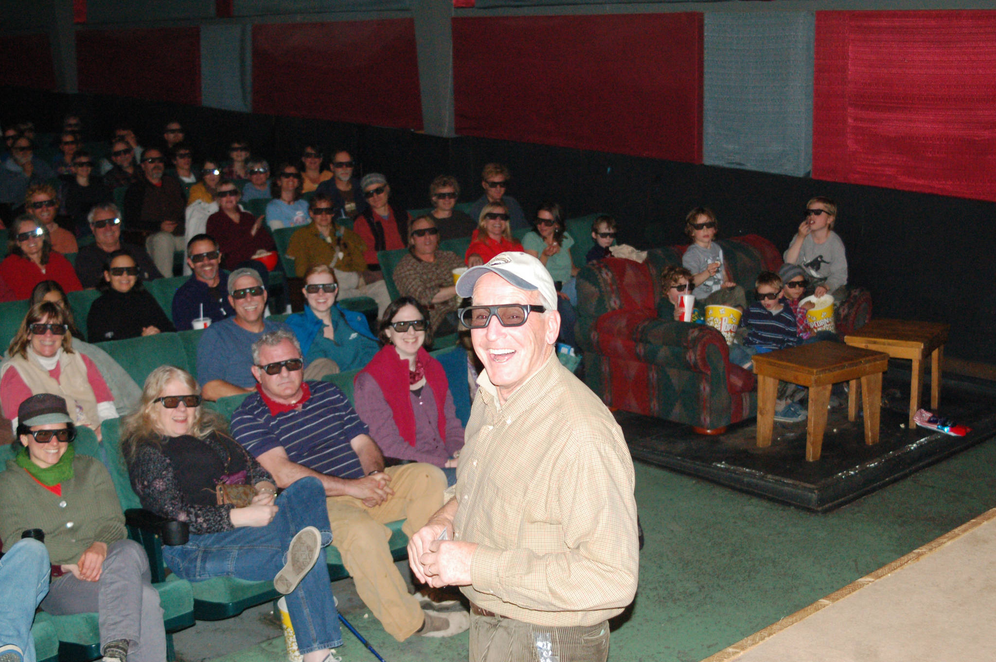 Homer Theatre owner Jamie Sutton, wearing special glasses, introduces Werner Herzog’s “Cave of Forgotten Dreams,” the first digital 3-D film shown at the 55-year-old theater for the 2011 Homer Documentary Film Festival. (Photo by Michael Armstrong, Homer News)