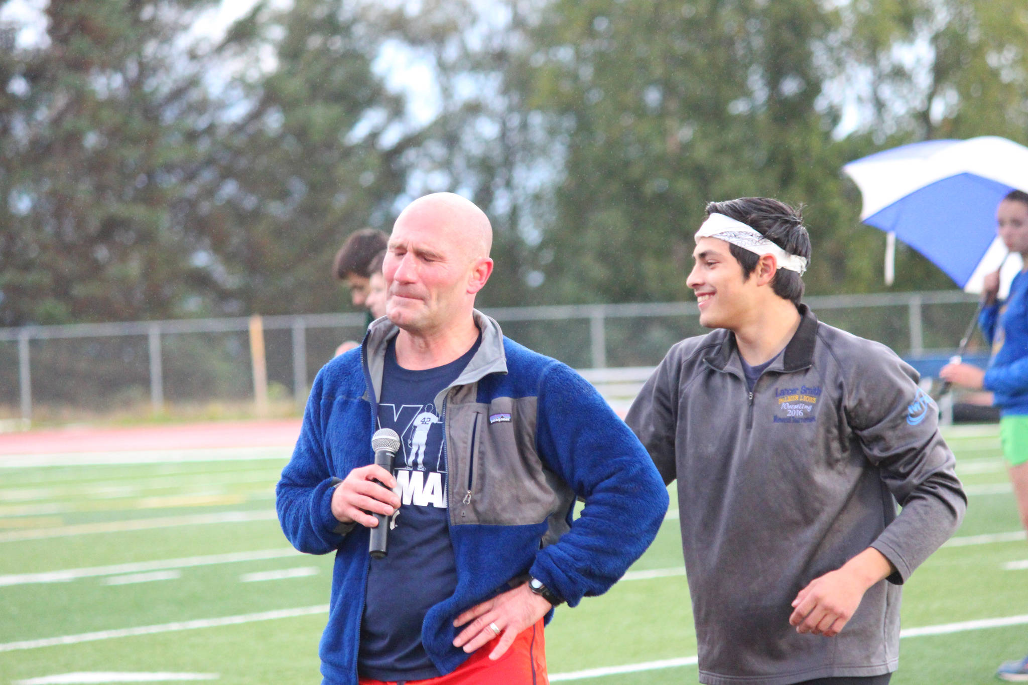 Homer High School Athletic Director Chris Perk gets emotional as his wife, Homer teacher Saundra Hudson, nears the finish line of a mile run during the Mariner Mile fundraising event Thursday, Sept. 14, 2017 at the track in Homer, Alaska. Hudson, an active member of the Homer running community who championed for the high school track to be put in, received a head injury after she slipped on ice while running in March. Thursday’s mile was the first time she’s run since the injury six months ago. (Photo by Homer News/Megan Pacer)