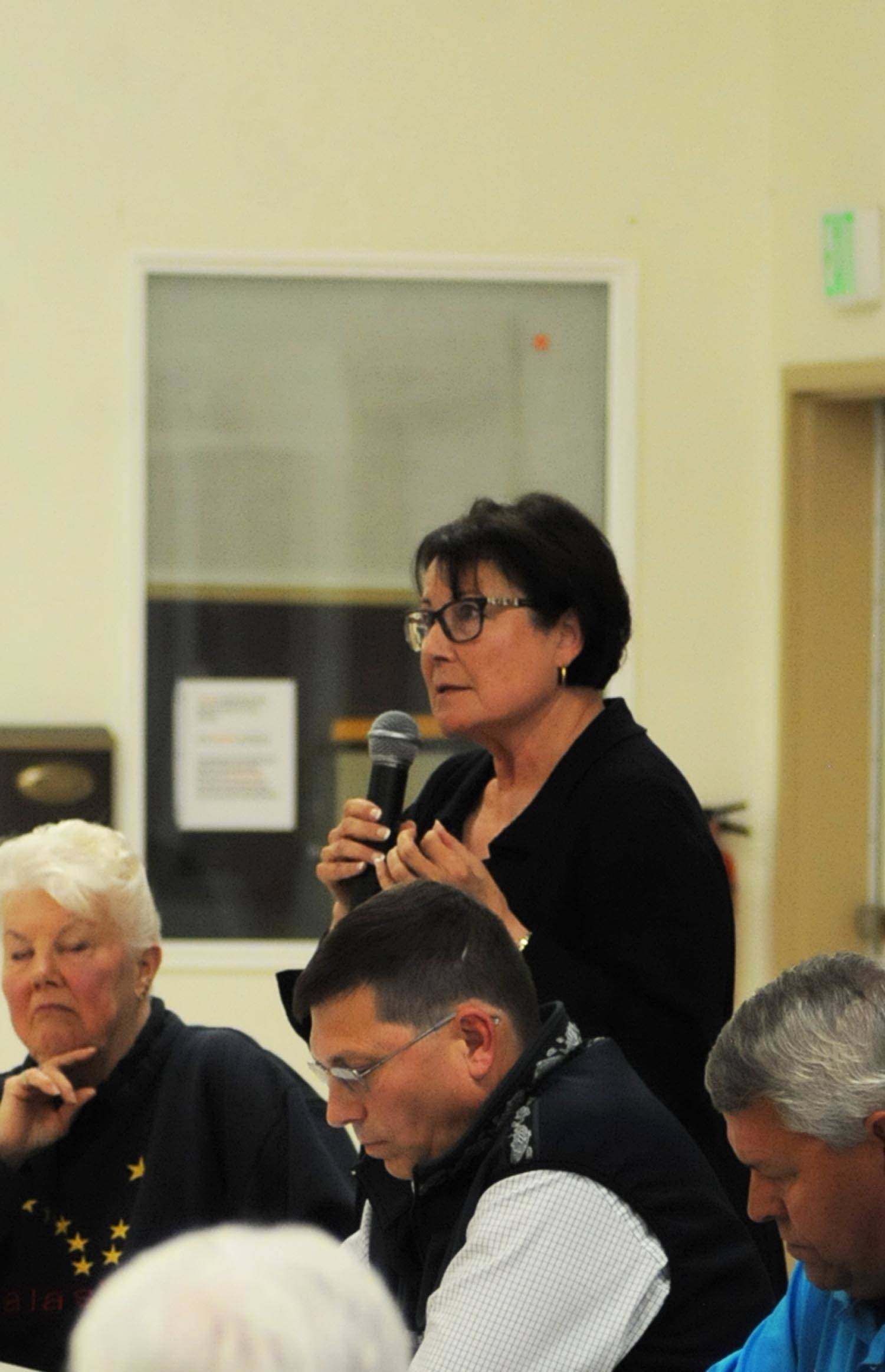 Linda Hutchings (standing), a candidate for Kenai Peninsula Borough mayor, answers a question during a forum with fellow candidates Dale Bagley (center) and Charlie Pierce (right) at the Funny River Community Center on Thursday, Aug. 16, 2017 in Funny River, Alaska. (Photo by Elizabeth Earl/Peninsula Clarion, file)