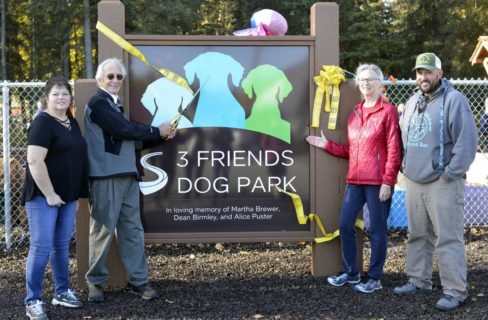 Soldotna Mayor Pete Sprague cuts the ribbon for the 3 Friends Dog Park on North Aspen Drive in Soldotna, Alaska on Saturday, September 30, 2017. “It’s kind of ironic for a former mailman to be dedicating a dog park,” Sprague said. He is joined by Connie Hocker, left, Nancy Courtright and Joel Todd. Hocker was a driving force behind the creation of the dog park. Courtright acted as the executor of the estate left by Martha Brewer, from which the park was funded. Todd, from Soldotna Parks and Recreation, “has been instrumental in making all the dreams come true in the park,” said Hocker. (Photo by Kat Sorensen/Peninsula Clarion)