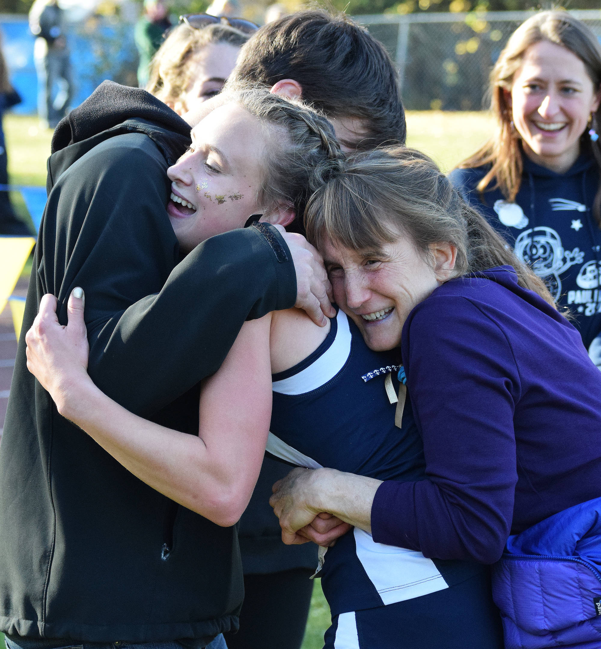Division II girls winner Autumn Daigle (center) receives hugs from her brother and mother Ann (right) Saturday at the ASAA First National Bank Alaska Cross-country State Championships at Bartlett High School. (Photo by Joey Klecka/Peninsula Clarion)