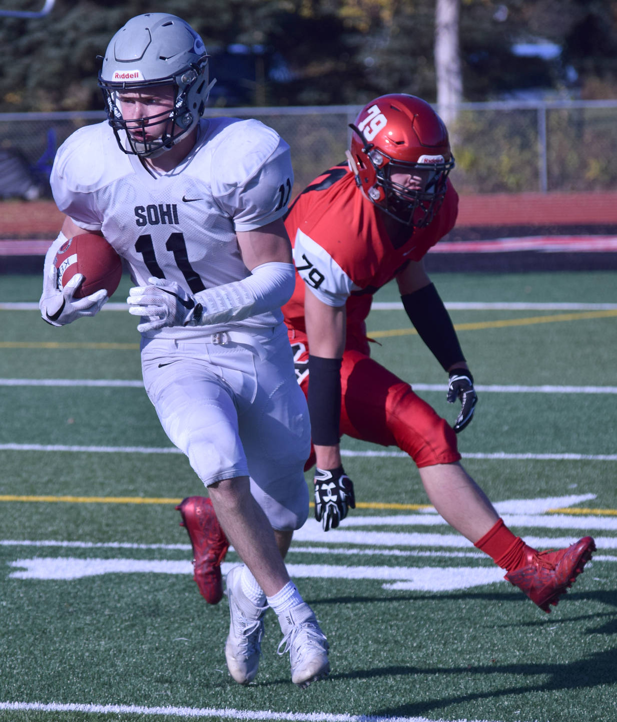 Soldotna’s Brenner Furlong turns upfield after eluding Kenai’s Jarett Wilson on a kickoff return Saturday, Sept. 30, 2017, at Ed Hollier Field in Kenai. (Photo by Jeff Helminiak/Peninsula Clarion)