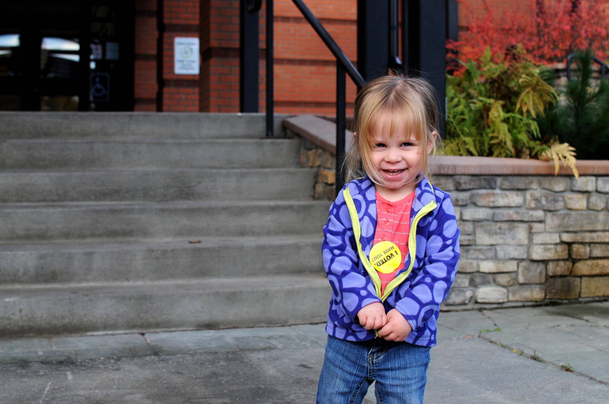 Aveline Russell, 2, shows off the sticker she got after going to Soldotna City Hall to vote with her family Tuesday, Oct. 3, 2017 in Soldotna, Alaska. Soldotna residents on Tuesday voted on two city council members and a mayor, all unopposed candidates, on one of three candidates for Kenai Peninsula Borough mayor and on two of the three borough propositions. (Photo by Elizabeth Earl/Peninsula Clarion)