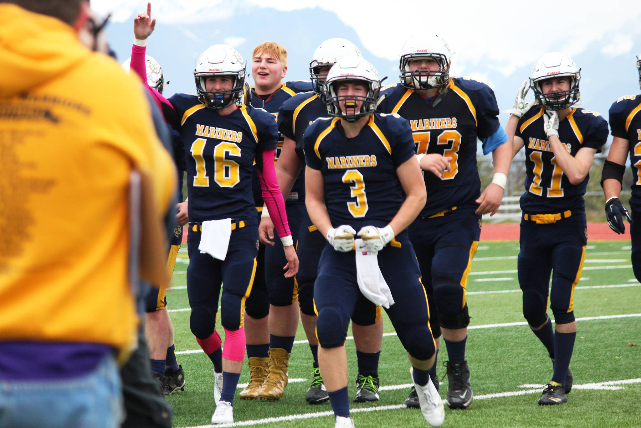 Seniors Justin Sumption (16) and Dawson Felde (3) come off the field celebrating with their teammates after defeating Ben Eielson High School in a playoff game Saturday, Oct. 7, 2017 at Homer High School in Homer, Alaska. The Mariners will now head to Palmer for the Division III state championship game. (Photo by Megan Pacer/Homer News)