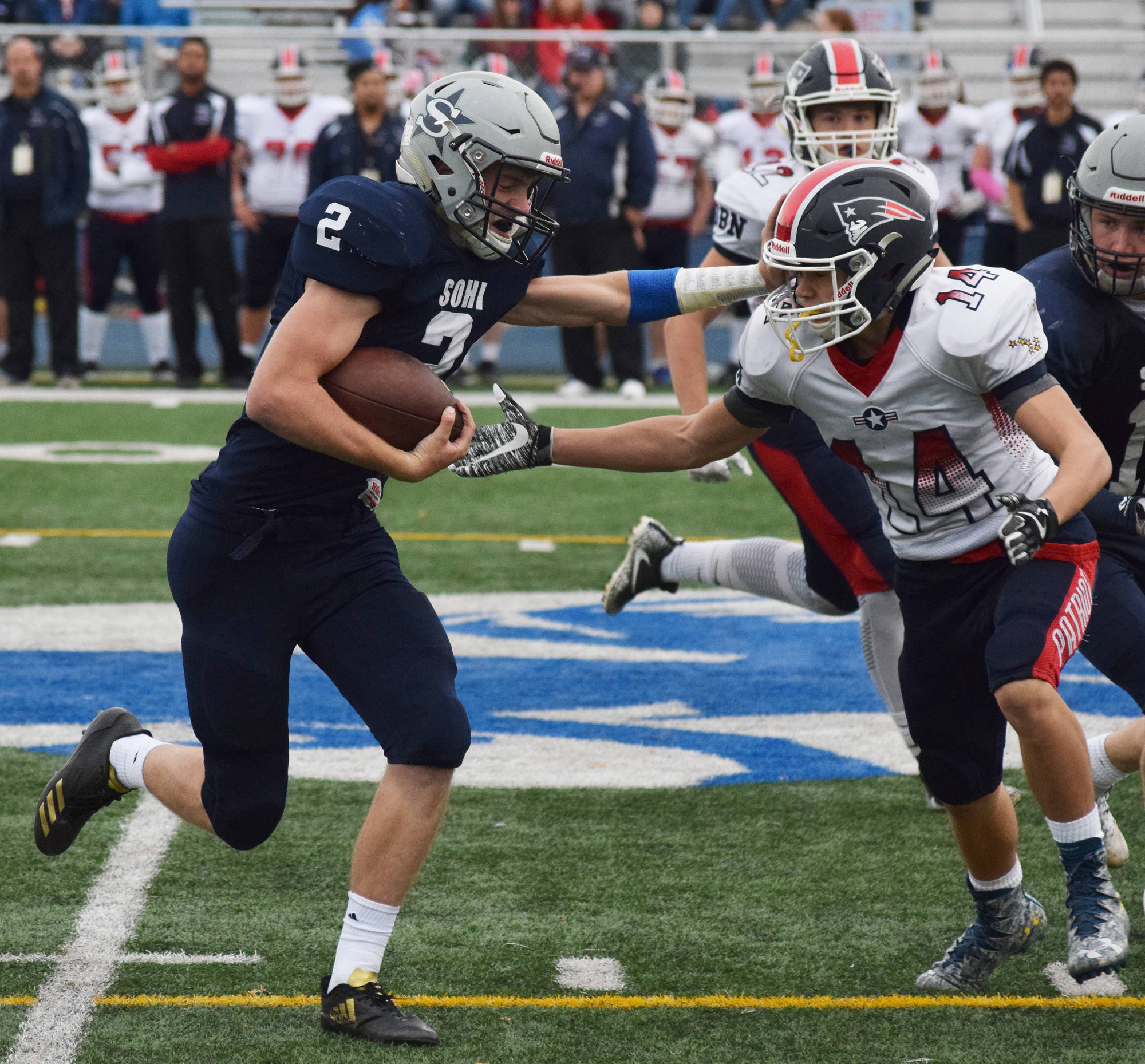 Soldotna running back Cody Quelland (2) stiff arms North Pole’s Chris Berrellez Saturday at the ASAA First National Bank state football semifinals at Palmer High School. (Photo by Joey Klecka/Peninsula Clarion)