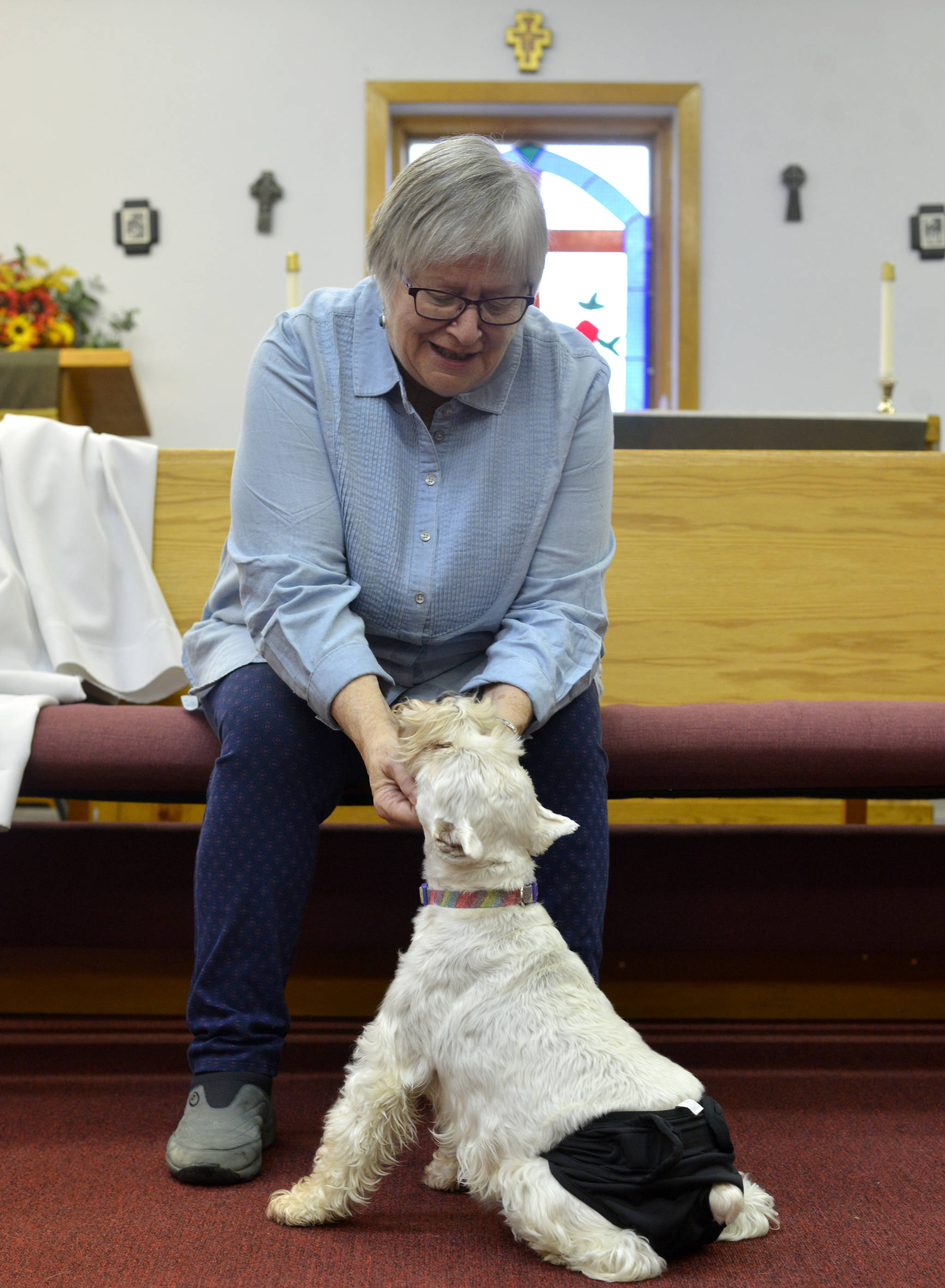 Marti Slater pets her dog, Abigal, while attending Blessing of the Animals held at St. Francis by the Sea in Kenai, Alaska on Oct. 8, 2017. The joint event was hosted St. Francis by the Sea Episcopal Church and Our Lady of the Angels Catholic Church. (Photo by Kat Sorensen/Peninsula Clarion)