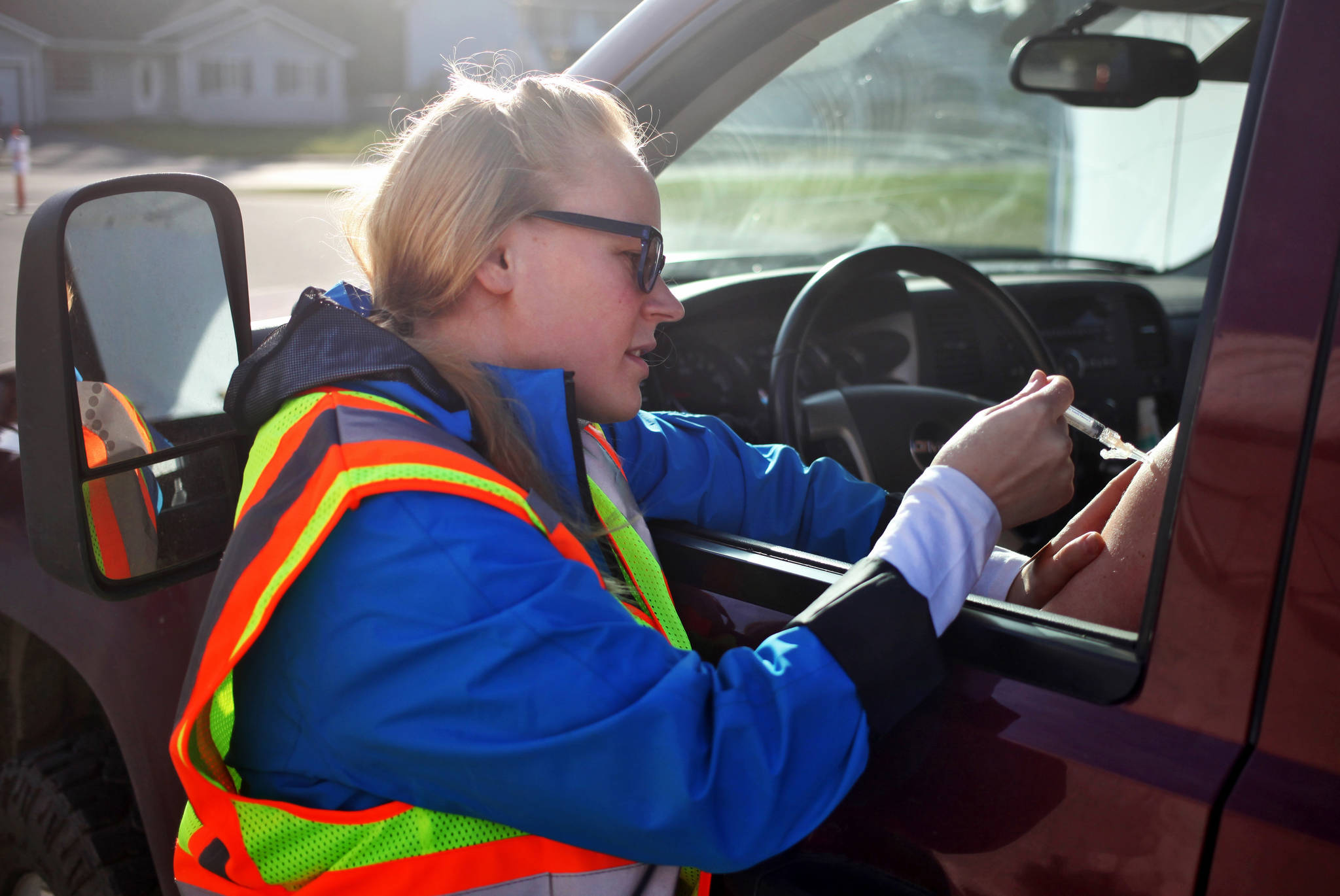 Student nurse Jana Cooper gives a flu shot through the window of a truck during Central Peninsula Hospital’s annual free drive-through flu vaccine clinic on Wednesday in Soldotna. Normally held in the Central Peninsula Hospital parking lot, this year’s event was down the street at Soldotna’s Our Lady of Perpetual Help Catholic Church, due to paving work in the hospital lot. In past years, student nurses have given over 400 shots at the clinic, and this year’s turnout seemed similarly large. Before the event began at 3 p.m, cars were lined up down the block as far as Rockwell Lane. (Photo by Ben Boettger/Peninsula Clarion)
