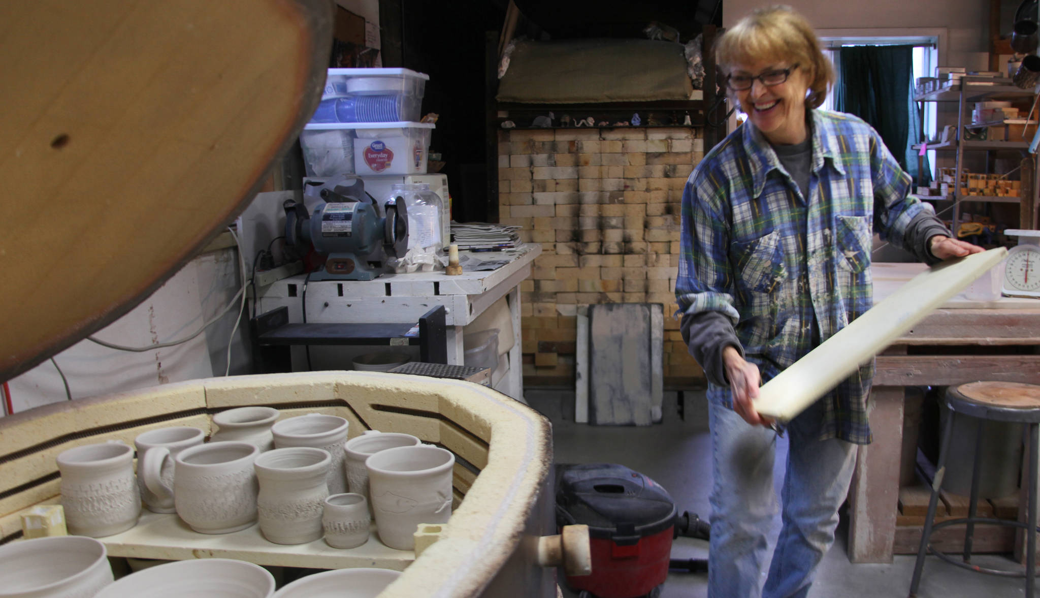 Kenai Potters Guild member Judy Brandt loads a gas-fired kiln with cups and bowls made by Guild members on Thursday, Oct. 12, 2017 at the group’s studio in Kenai. The Potters guild is preparing for a busy winter with weekly classes, a “Clay on Display” art show presently sitting in the Kenai Fine Art Center gallery, and a new kind of kiln which they’ll be experimenting with this weekend. (Ben Boettger/Peninsula Clarion)