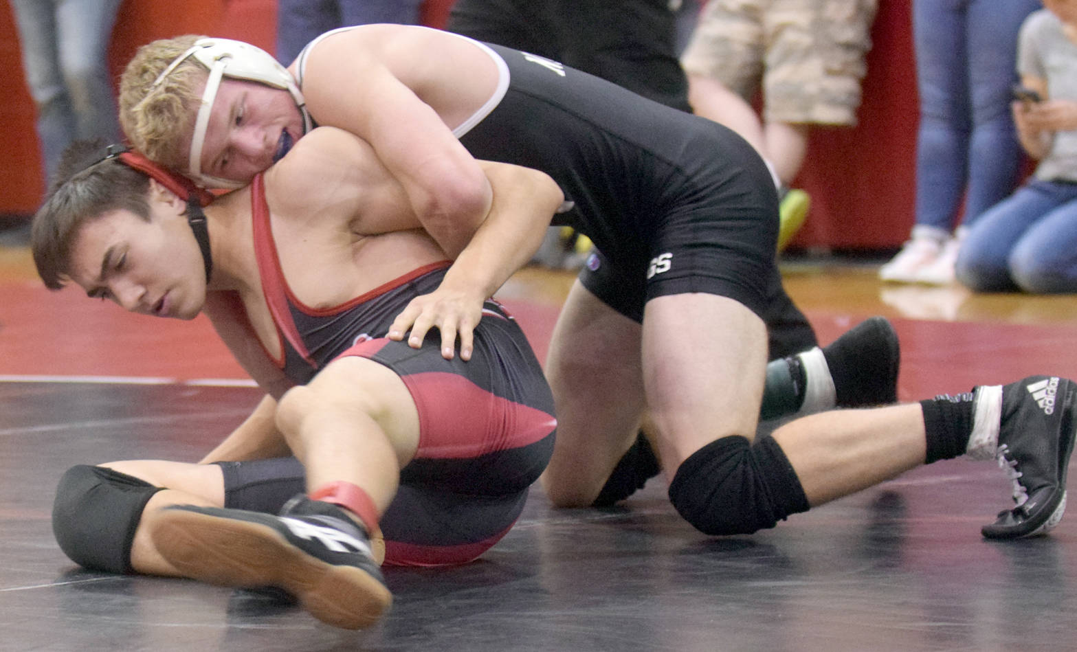 Nikiski’s Justin Cox controls Kenai Central’s Brandon Kroto on Saturday, Oct. 14, 2017, at the Luke Spruill Memorial Tournament at Kenai Central High School. Cox took a 13-1 major decision en route to winning first at 138 pounds. (Photo by Jeff Helminiak/Peninsula Clarion)