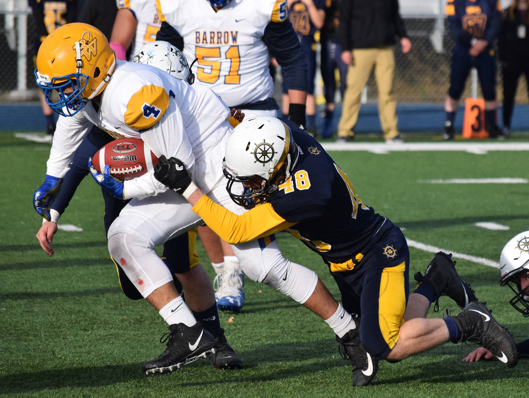 Homer senior Chris Cudaback (48) tackles Utqiagvik running back Ben Heather Saturday in the ASAA First National Bank Division III state championship at Machetanz Field in Palmer. (Photo by Joey Klecka/Peninsula Clarion)