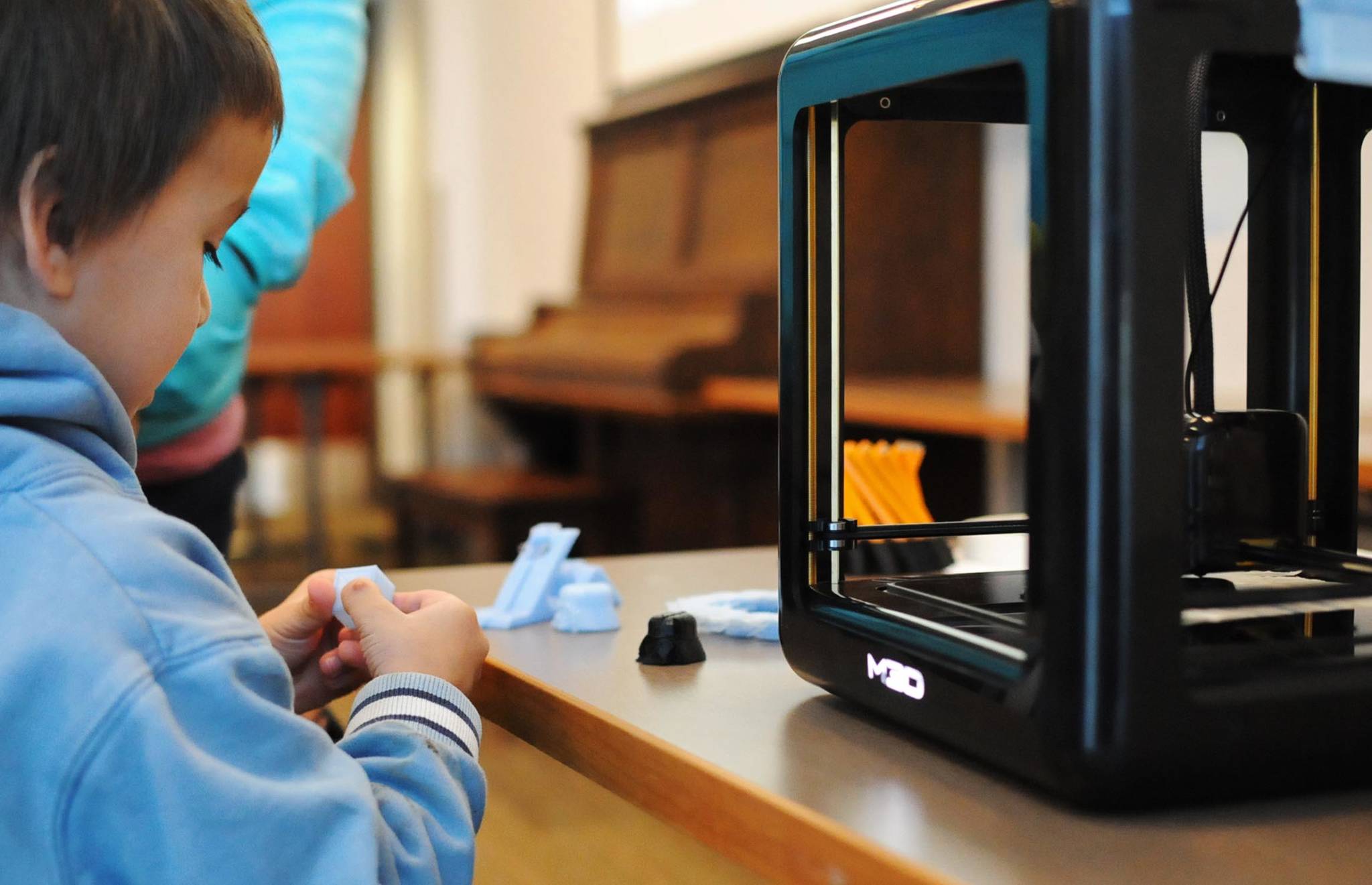Isaac Perry, 5, checks out a cube produced by the Soldotna Public Library’s new 3D printer during a demonstration at the library Thursday, Oct. 19, 2017 in Soldotna, Alaska. The library acquired the machine, which can print three-dimensional objects out of plastic based on a submitted pattern, in July and is now making it available for public use. It’s currently free, supported by funds from the Soldotna Library Friends, with a suggested donation of $3 per print. Eventually, if demand outpaces supply, the library expects to have to establish a fee, according to the 3D printer policy. (Photo by Elizabeth Earl/Peninsula Clarion)