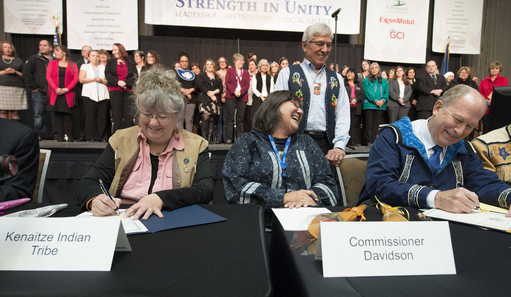 Kenaitze Tribal Council Vice-Chairperson Bernadine Atchison and Gov. Bill Walker, fourth from left, sign the Alaska Tribal Child Welfare Compact during a ceremony Thursday at the Alaska Federation of Natives Convention in Anchorage. Department of Health and Social Services Commissioner Valerie Davidson and Lt. Gov. Byron Mallott celebrate the moment. The government-to-government agreement will make it possible for participating tribes and tribal organizations to provide child welfare services that would otherwise be provided by the Alaska Office of Children&