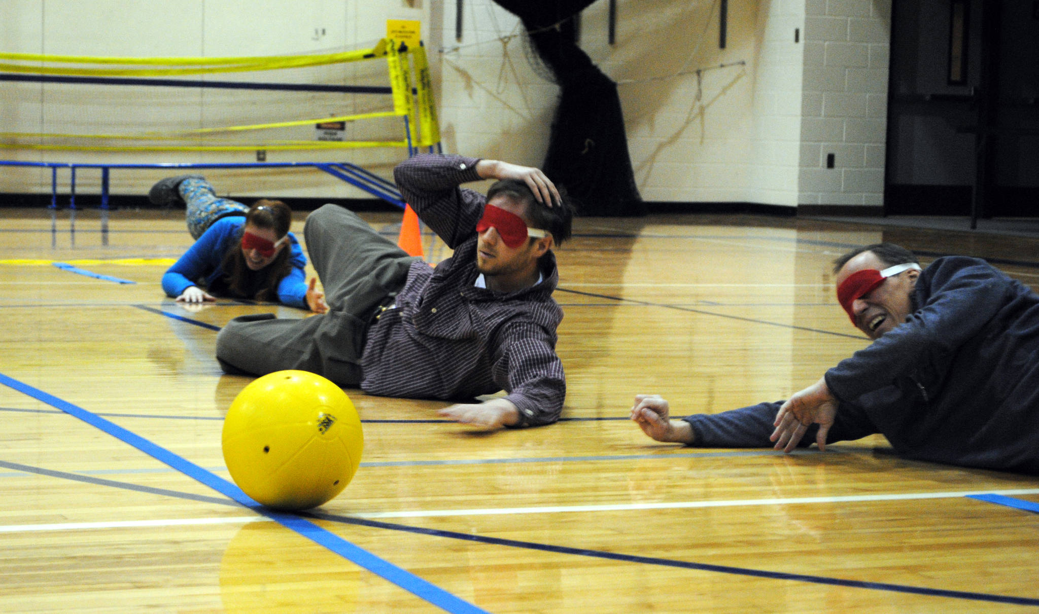River City Academy teachers Annaleah Karron, Chris Kolishchak and Thomas Degray defend their goal in a Monday morning game of goalball at River City Academy in Soldotna, Alaska. Since the game is meant to be played by those with visual impairments, each team member had to wear blindfolds and listen for the ball, which is equipped with a jingling bell. (Photo by Kat Sorensen/Peninsula Clarion)