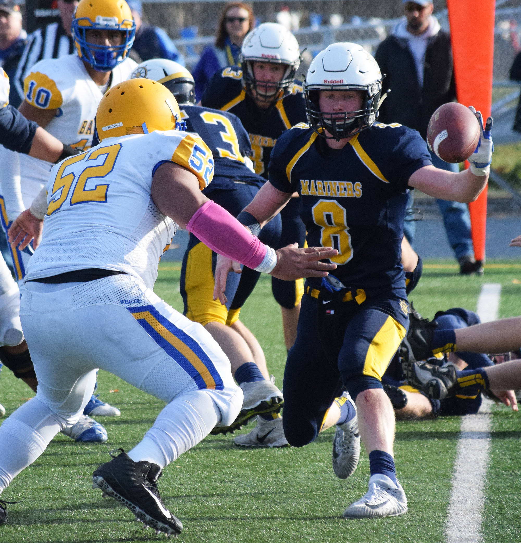 Homer senior Teddy Croft (8) pitches a handoff to a teammate with Utqiagvik’s Oneahi Talaiasi (52) pressuring him Saturday, Oct. 14, 2017, in the ASAA First National Bank Division III state championship at Machetanz Field in Palmer. (Photo by Joey Klecka/Peninsula Clarion)