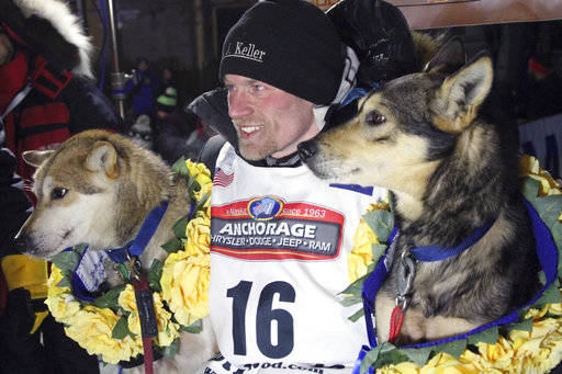 In this March 15, 2016, file photo, Dallas Seavey poses with his lead dogs Reef, left, and Tide after finishing the Iditarod Trail Sled Dog Race in Nome, Alaska. Seavey won his third straight Iditarod, for his fourth overall title in the last five years. Four-time Iditarod champion Dallas Seavey denies he administered banned drugs to his dogs in this year’s race, and has withdrawn from the 2018 race in protest. The Iditarod Trail Committee on Monday identified Seavey as the musher who had four dogs test positive for a banned opioid pain reliever after finishing the race last March in Nome. (AP Photo/Mark Thiessen)