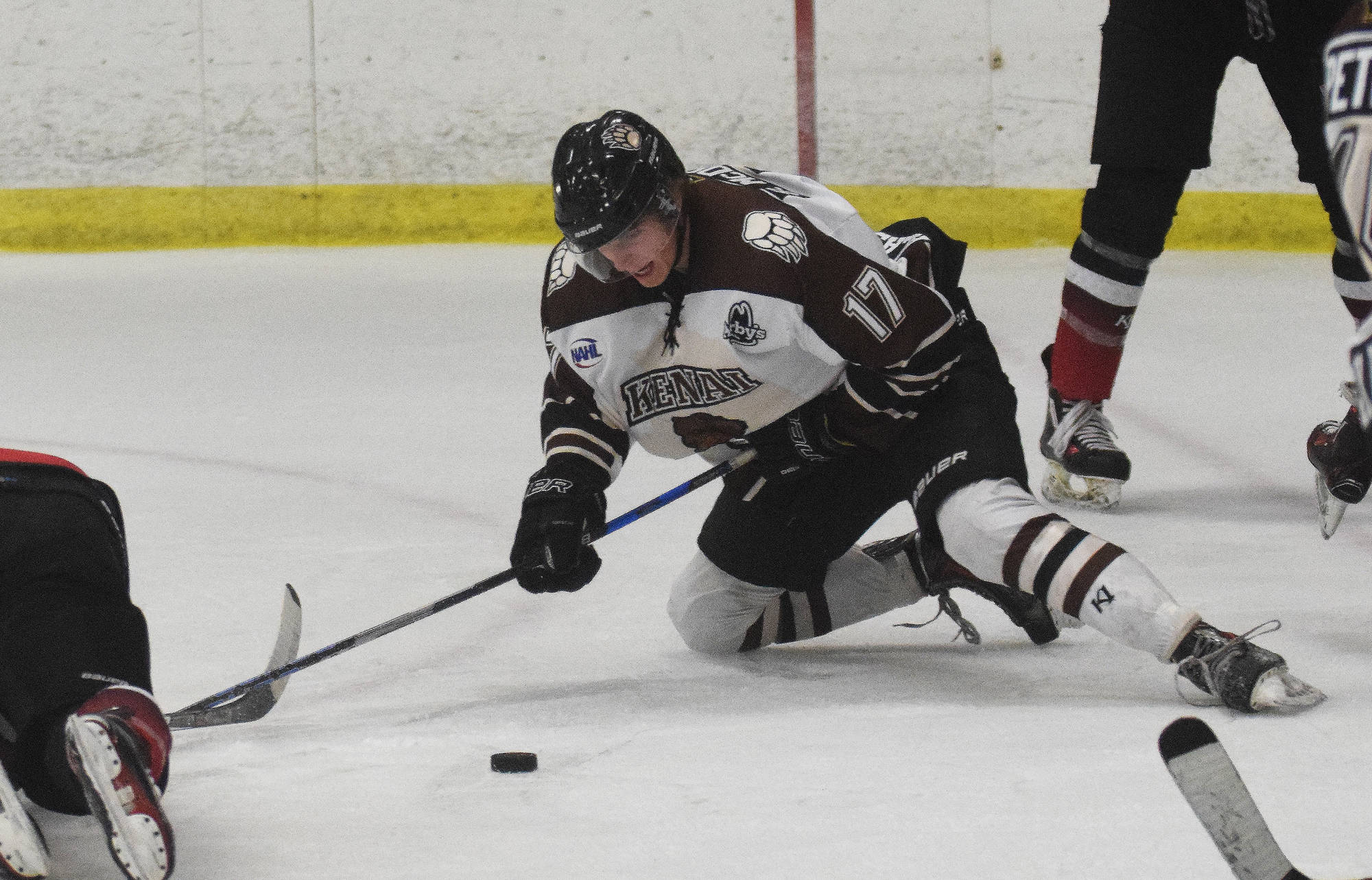 Kenai River Brown Bears forward Sutton McDonald eyes the puck in front of a Minnesota player Friday night at the Soldotna Regional Sports Complex. (Photo by Joey Klecka/Peninsula Clarion)
