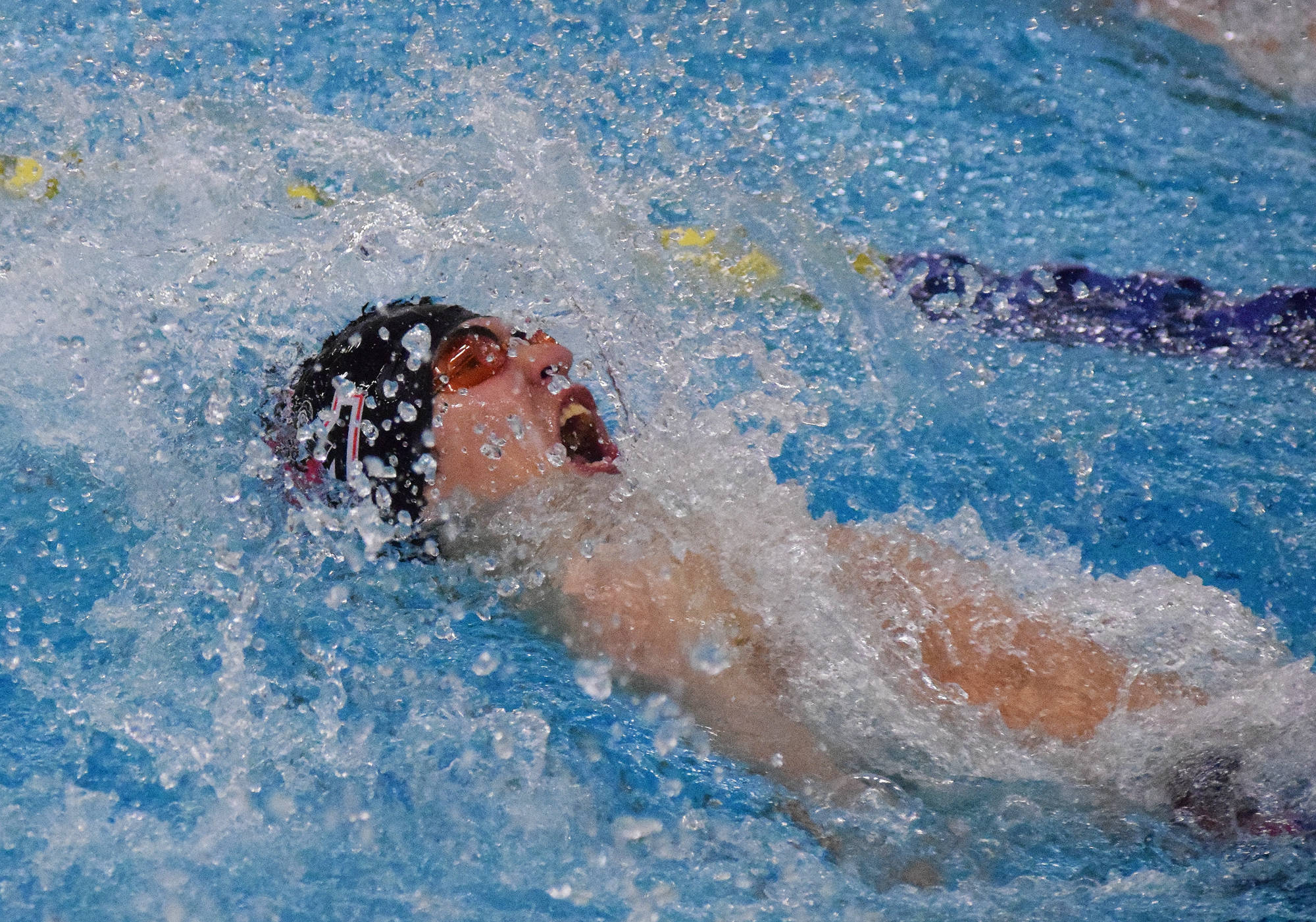 Kenai Central’s Savaii Heaven races to the third-place finish in the boys 100-yard backstroke Saturday at the ASAA First National Bank State Swimming & Diving Championships at the Bartlett High pool. (Photo by Joey Klecka/Peninsula Clarion)