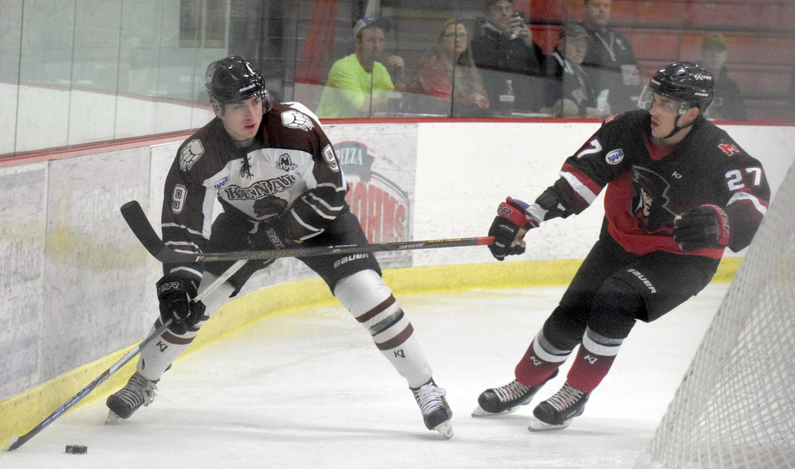 Kenai River Brown Bears forward Alex Klekotka tries to make a play behind the net on Minnesota Magicians defenseman Matt Denman on Thursday, Oct. 26, 2017, at the Soldotna Regional Sports Complex. (Photo by Jeff Helminiak/Peninsula Clarion)