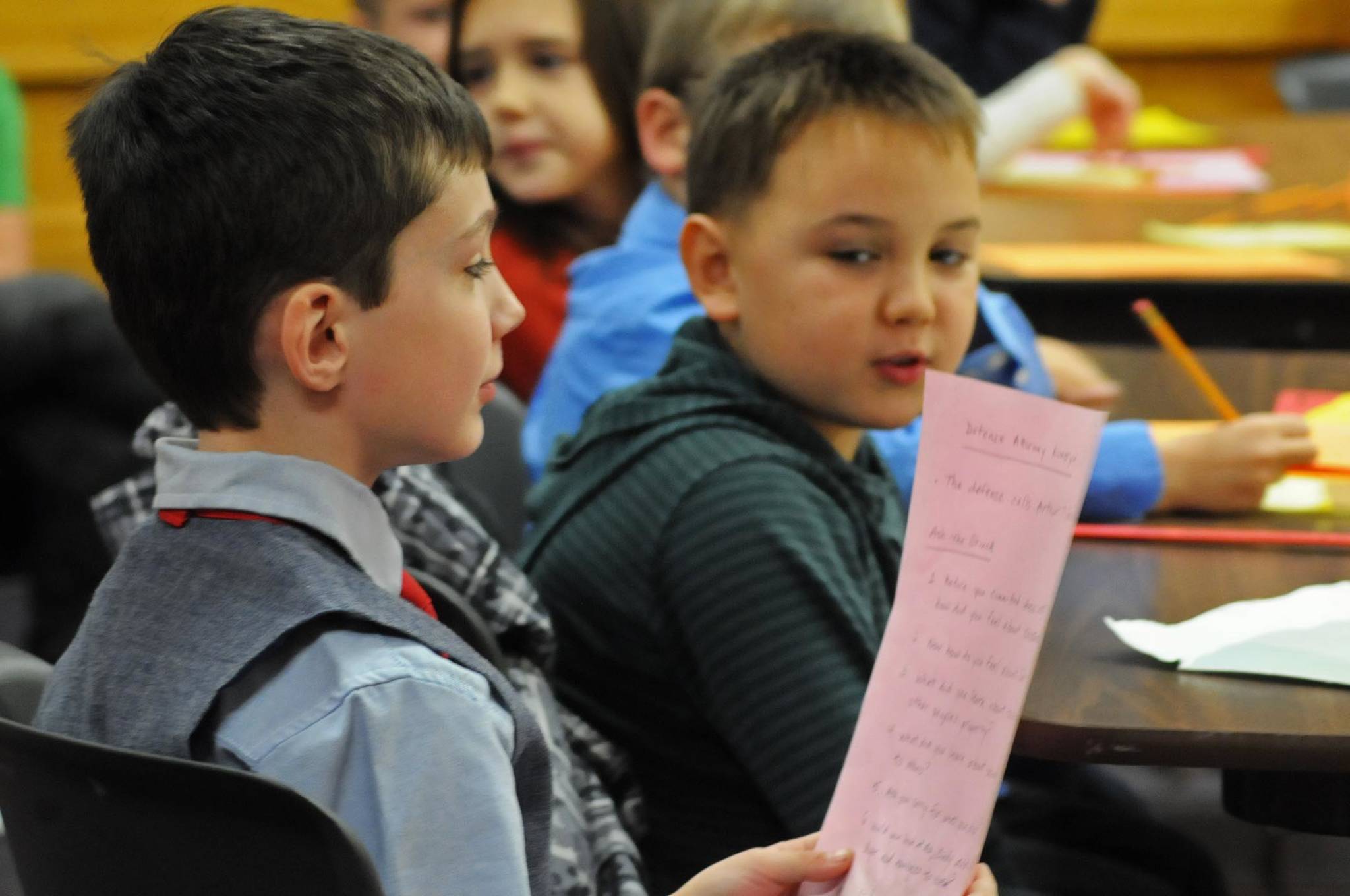 Koebrien Lazenby, a second-grader at Kalifornsky Beach Elementary School, reads from his list of questions for a witness during the class’s mock trial of “Arthur T. Grinch” based on the Dr. Seuss classic “How the Grinch Stole Christmas” on Thursday, Nov. 9, 2017 in Kenai, Alaska. The class has been studying civics and learning about the court process and put on a mock sentencing hearing, complete with witnesses and a jury composed of students’ parents and K-Beach Elementary Principal Nate Crabtree. (Photo by Elizabeth Earl/Peninsula Clarion)