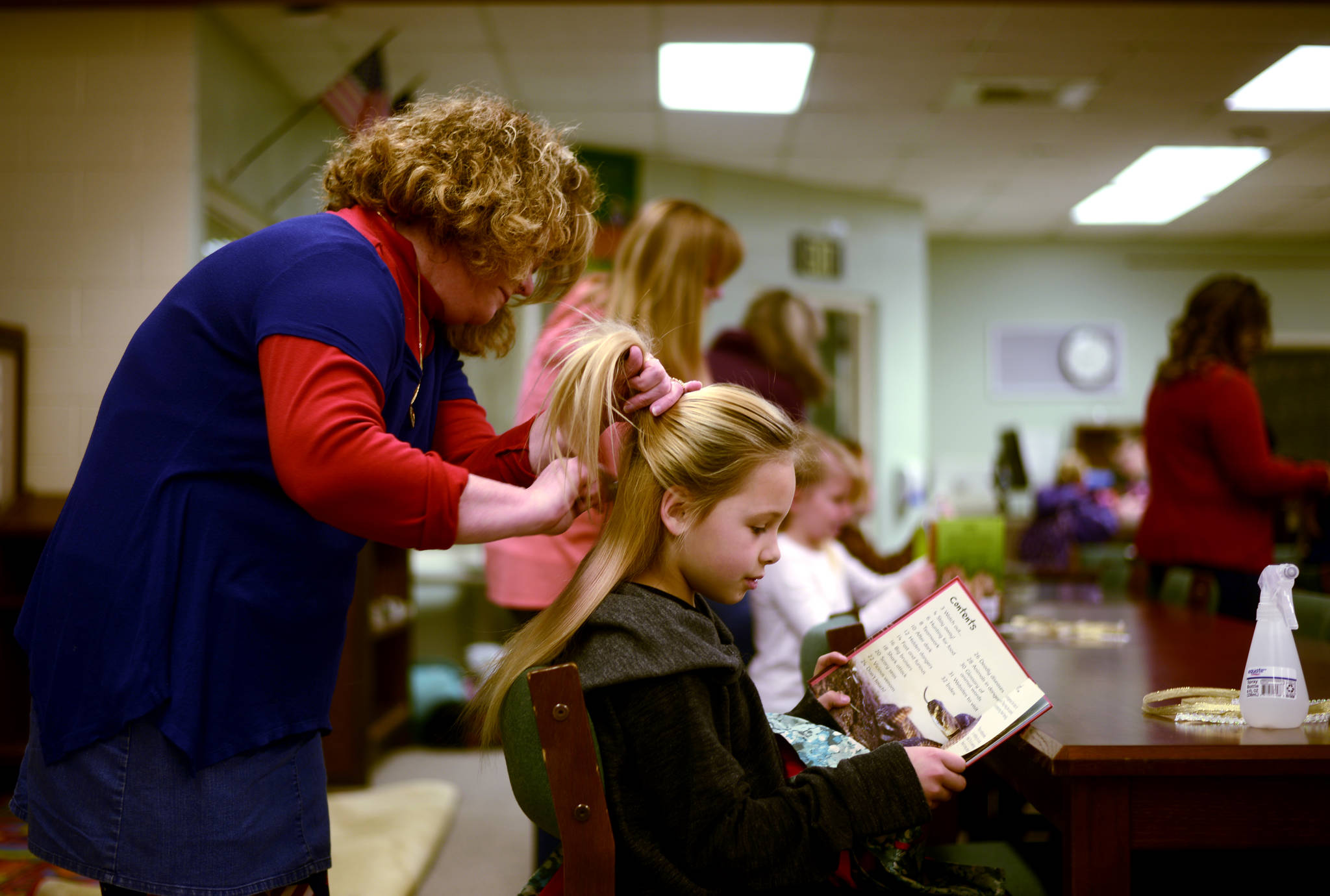 Teachers and students at Nikiski North Star Elementary in Nikiski, Alaska filled the library on Thursday, Nov. 9 morning at the first Stories with Style, a weekly event that transforms the library into a hair salon. (Photo by Kat Sorensen/Peninsula Clarion)