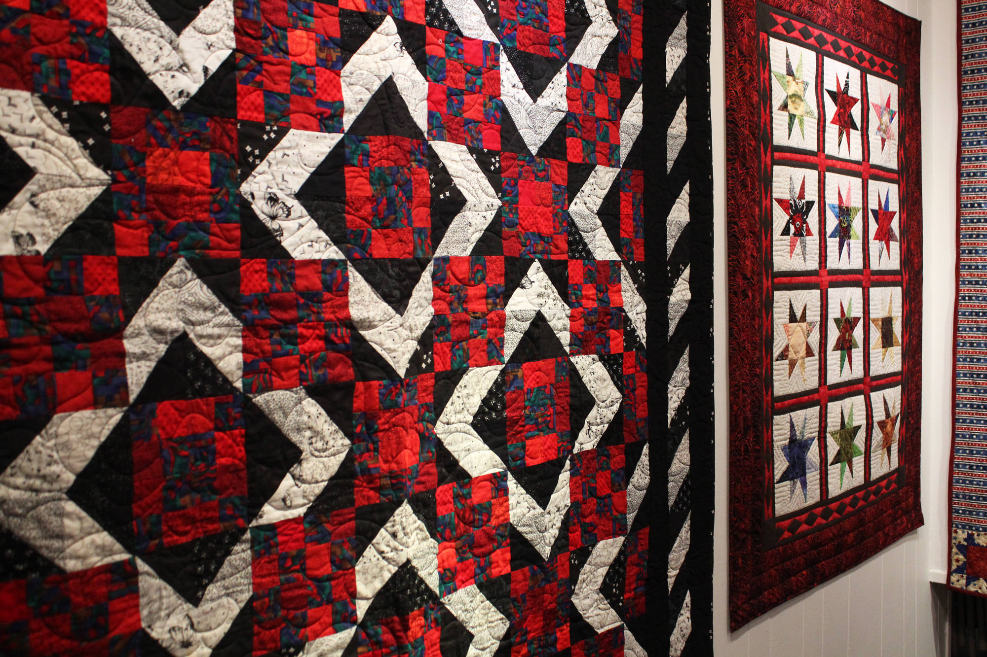 The Kachemak Bay Quilters spend a lot of their time creating quilts for victims of house fires, like the ones shown here during a First Friday exhibit Nov. 3 at the Homer Council on the Arts in Homer. (Photo by Megan Pacer/Homer News)
