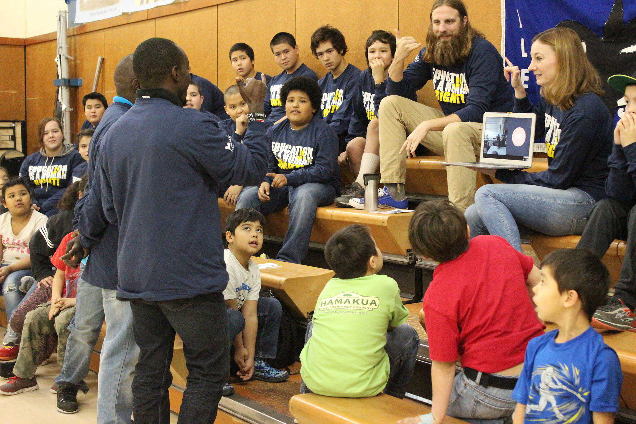 Kimani Nyambura, foreground, signs to a deaf student from Nanwalek while the school skypes into his presentation with human rights lawyer Chris Mburu Thursday, Nov. 16, 2017 at Port Graham School in Port Graham, Alaska. The pair, who are the subject of a documentary called “A Small Act,” presented about their journeys to education from a small village in Kenai to several Kenai Peninsula schools this week. (Photo by Megan Pacer/Homer News)