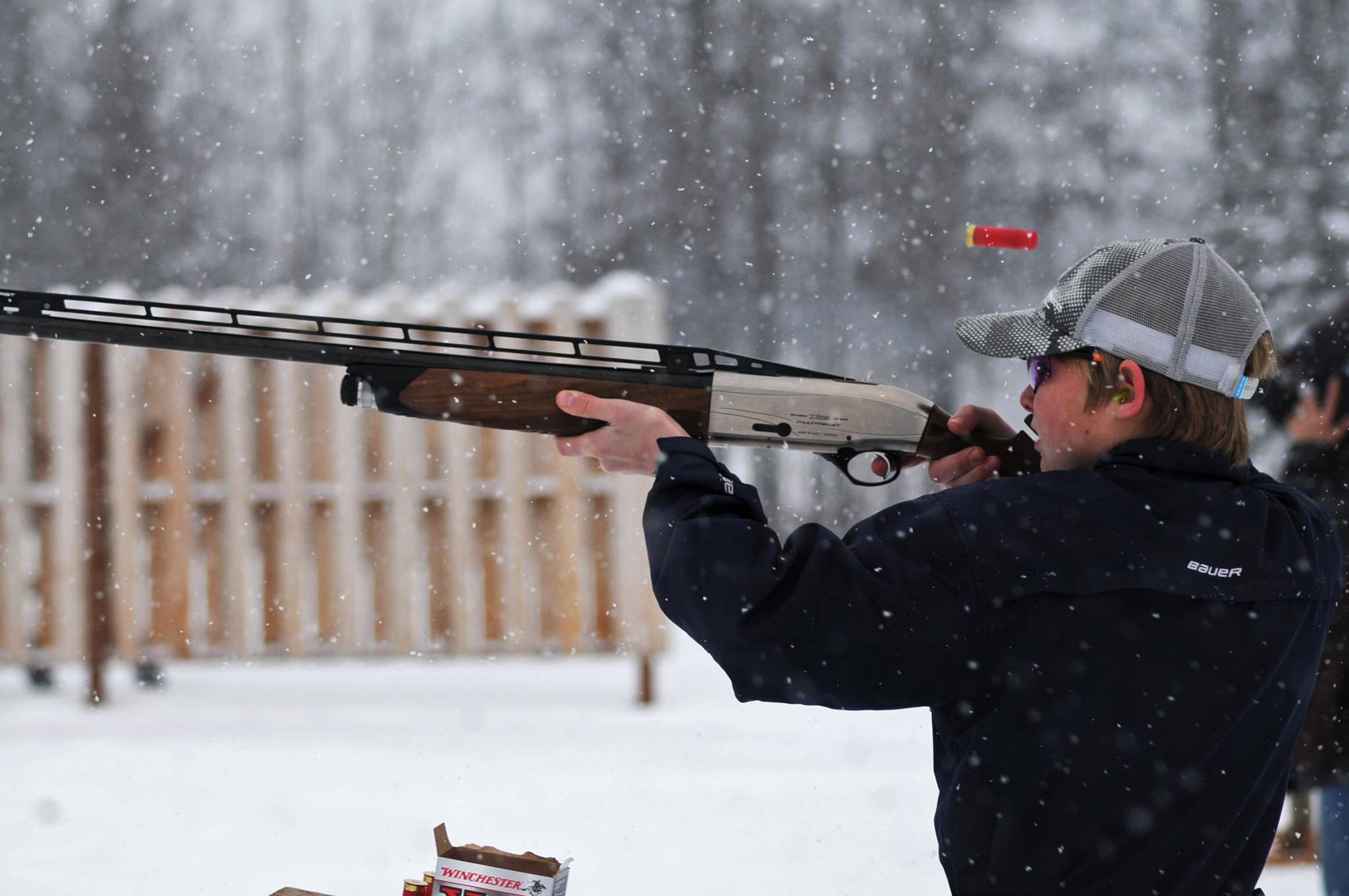 Dawson Lockwood lets off a shot at a flying clay target through filtering snow during an event at the Snowshoe Gun Club on Sunday, Nov. 19, 2017 in Kenai, Alaska. A group of shooters gathered at the shooting range Sunday as part of the club’s annual Thanksgiving event, which features “Annie Oakley” trap shooting game as well as several other events. Despite the snow, a number of people turned out to try the shooting games and to enjoy the warm central building on a chilly Sunday afternoon. (Photo by Elizabeth Earl/Peninsula Clarion)