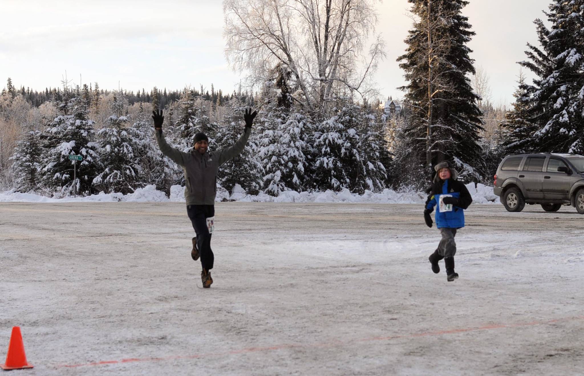 Ernest Umarwadia (left), of Houston, Texas, crosses the finish line to win the 5K Turkey Trot race at the Soldotna Regional Sports Complex on Thursday, Nov. 23, 2017 in Soldotna, Alaska. The organizers of the event, which also included a 1-mile race, donated all the proceeds to Freedom House, a Soldotna-based nonprofit sober living home for women recovering from addiction. (Photo by Elizabeth Earl/Peninsula Clarion)