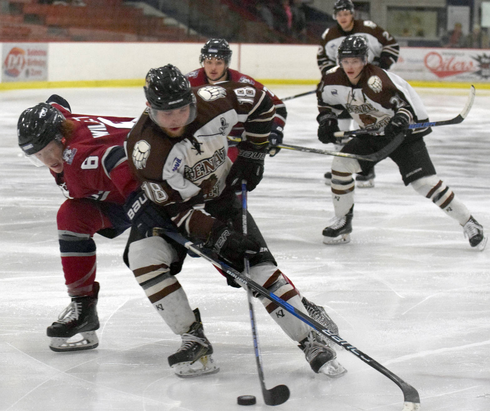 Kenai River Brown Bears forward Gil Garcia drives the net on Fairbanks Ice Dogs defenseman Jake Willets on Friday, Nov. 24, 2017, at the Soldotna Regional Sports Complex. (Photo by Jeff Helminiak/Peninsula Clarion)