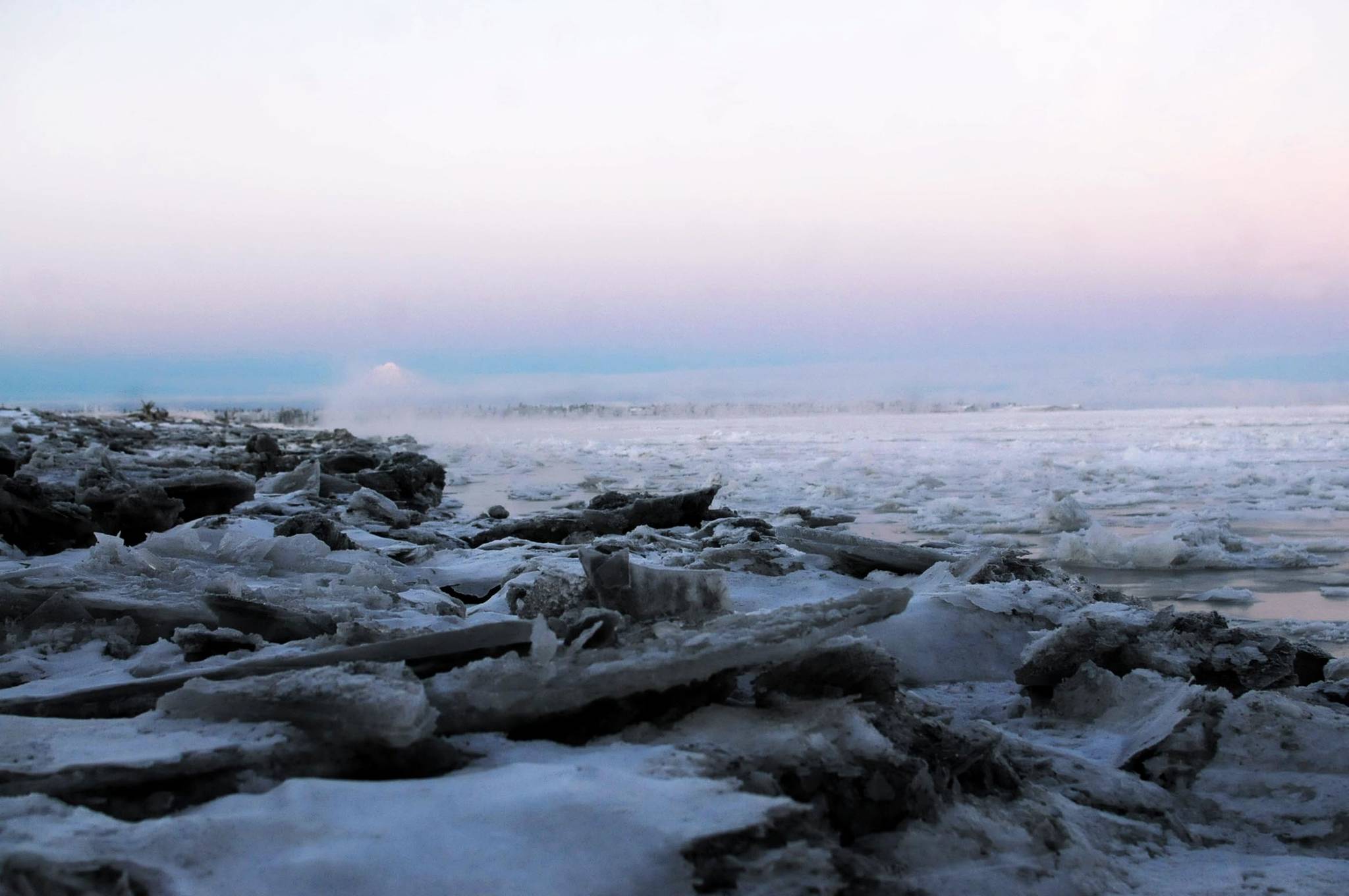 Mist rises over the broken ice on the bank of the Kenai River just downstream of the Warren Ames Bridge on Sunday, Nov. 26, 2017 in Kenai, Alaska. The Kenai River downstream of the bridge was completely frozen Sunday morning. The weekend brought deep freezing temperatures to the central Kenai Peninsula, plunging to -4 degrees Fahrenheit Sunday morning with a high of 17 degrees during the day. The National Weather Service forecasts temperatures to increase tomorrow and continue in the upper 20s and low 30s through the week, with increased chances of snow through Thursday. (Photo by Elizabeth Earl/Peninsula Clarion)