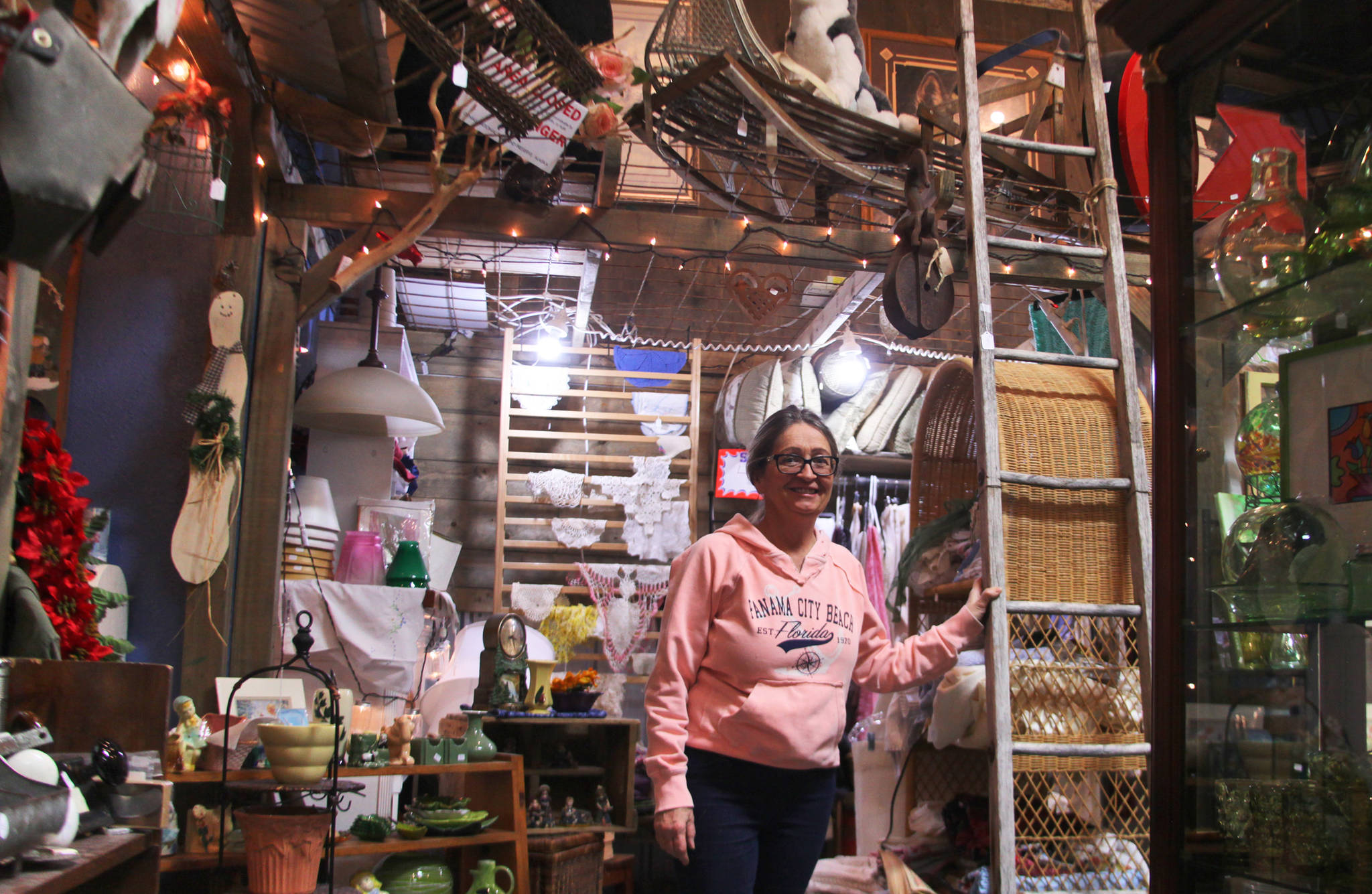 Owner Jeanie Carter of the Curiosity Shop poses among her merchandise on Monday, Nov. 27, 2017 in Kenai, Alaska. Like many small business owners in Kenai and Soldotna, Carter said the Thanksgiving weekend drew a lot of customers to her store, which offers gifts with local history that aren’t available in larger chain stores. (Ben Boettger/Peninsula Clarion)