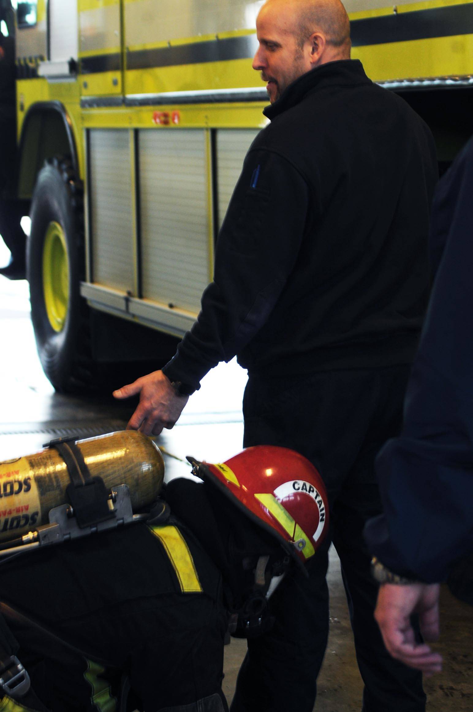 Kenai Fire Department firefighter Scott Summers leads a group of Kenai River Brown Bears hockey players who are blinded with blackout masks during a tour and training demonstration at the Kenai Emergency Operations Center on the Kenai Municipal Airport on Tuesday, Nov. 28, 2017 in Kenai, Alaska. Kenai Fire Department firefighters walked the Brown Bears players through some of the training and tools firefighters use to give them an idea of what a career in fire response is like. (Photo by Elizabeth Earl/Peninsula Clarion)