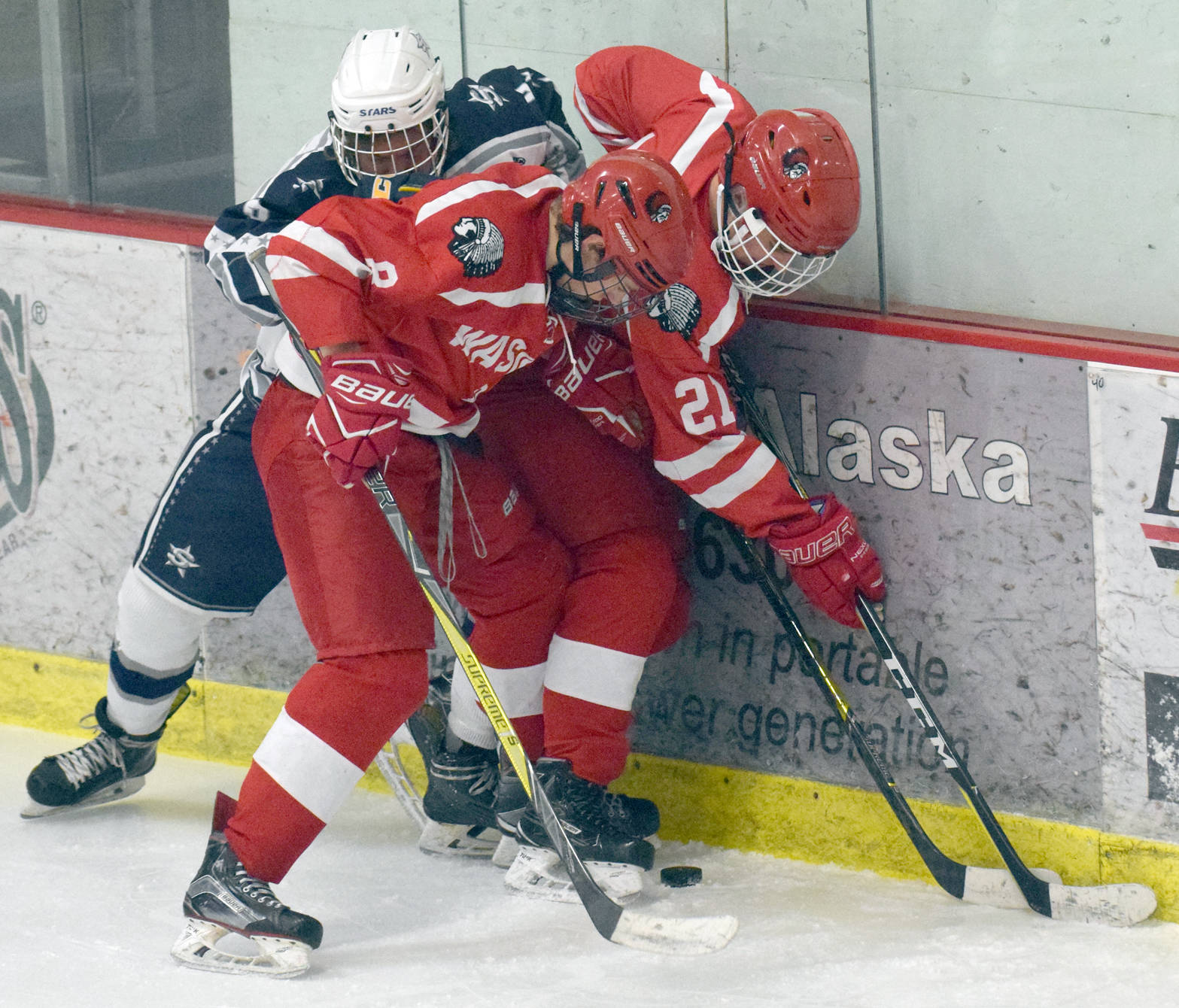 Soldotna’s JD Schmelzenbach battles with Wasilla’s McKinley Larson and Langston Bouma for the puck Friday, Dec. 1, 2017, at the Soldotna Regional Sports Complex. (Photo by Jeff Helminiak/Peninsula Clarion)