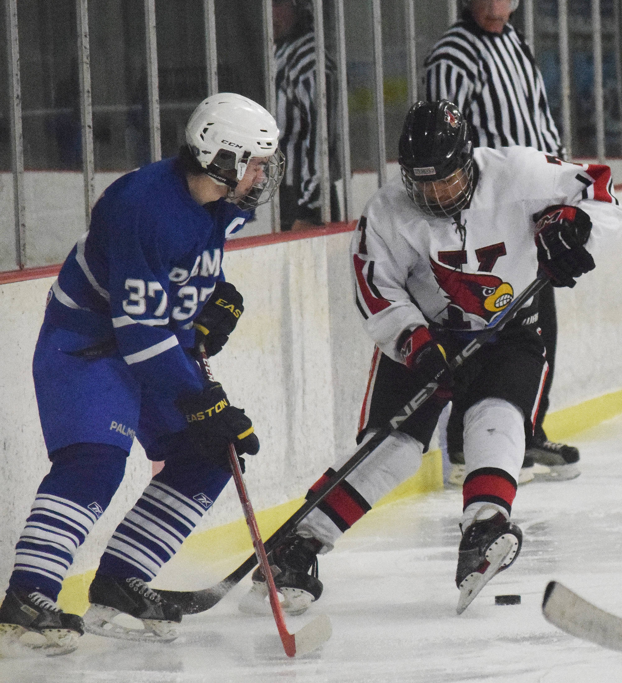 Kenai Central skater Jacob Keels scrambles to find the puck in front of Palmer’s Noah Keil, Friday at the Kenai Multipurpose Facility. (Photo by Joey Klecka/Peninsula Clarion)