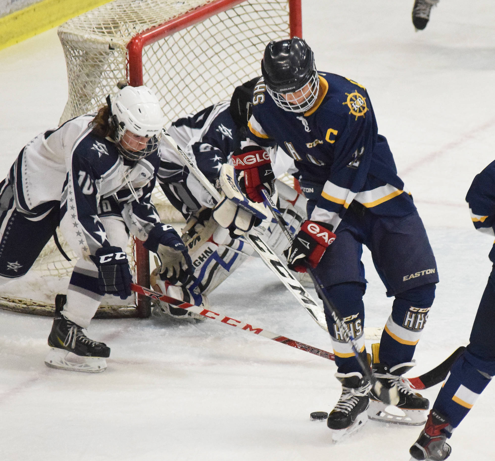 Homer’s Dimitry Kuzmin (front) works for a shot against Soldotna goaltender Kenzie Powell Tuesday night at the Soldotna Regional Sports Complex. (Photo by Joey Klecka/Peninsula Clarion)
