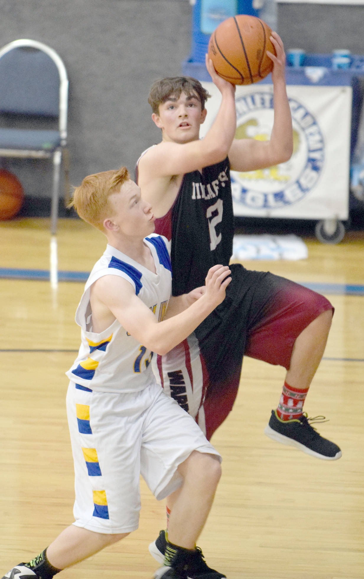 Nikolaevsk’s Chris Jackson drives on Cook Inlet Academy’s Lucas Cragg on Friday, Dec. 15, 2017, at Cook Inlet Academy. (Photo by Jeff Helminiak/Peninsula Clarion)