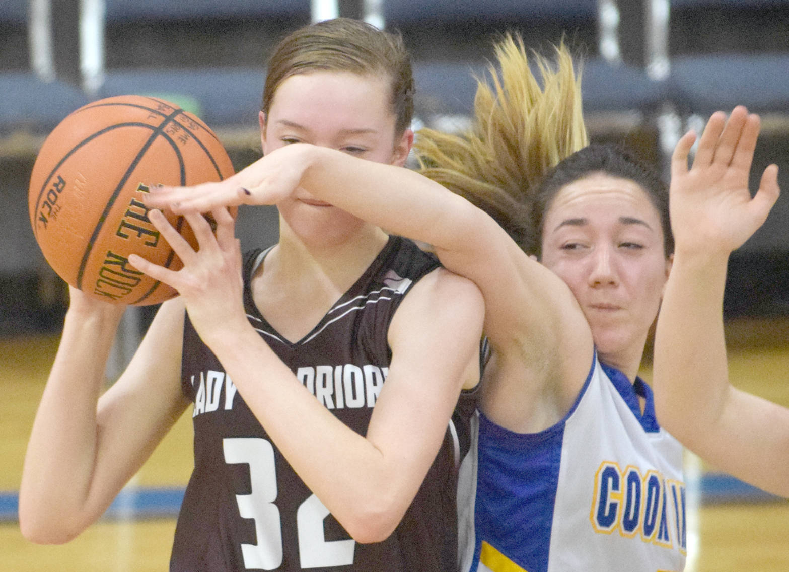 Nikolaevsk’s Elizabeth Fefelov holds off a steal attempt by Cook Inlet Academy’s Breona Delon on Friday, Dec. 15, 2017, at Cook Inlet Academy. (Photo by Jeff Helminiak/Peninsula Clarion)