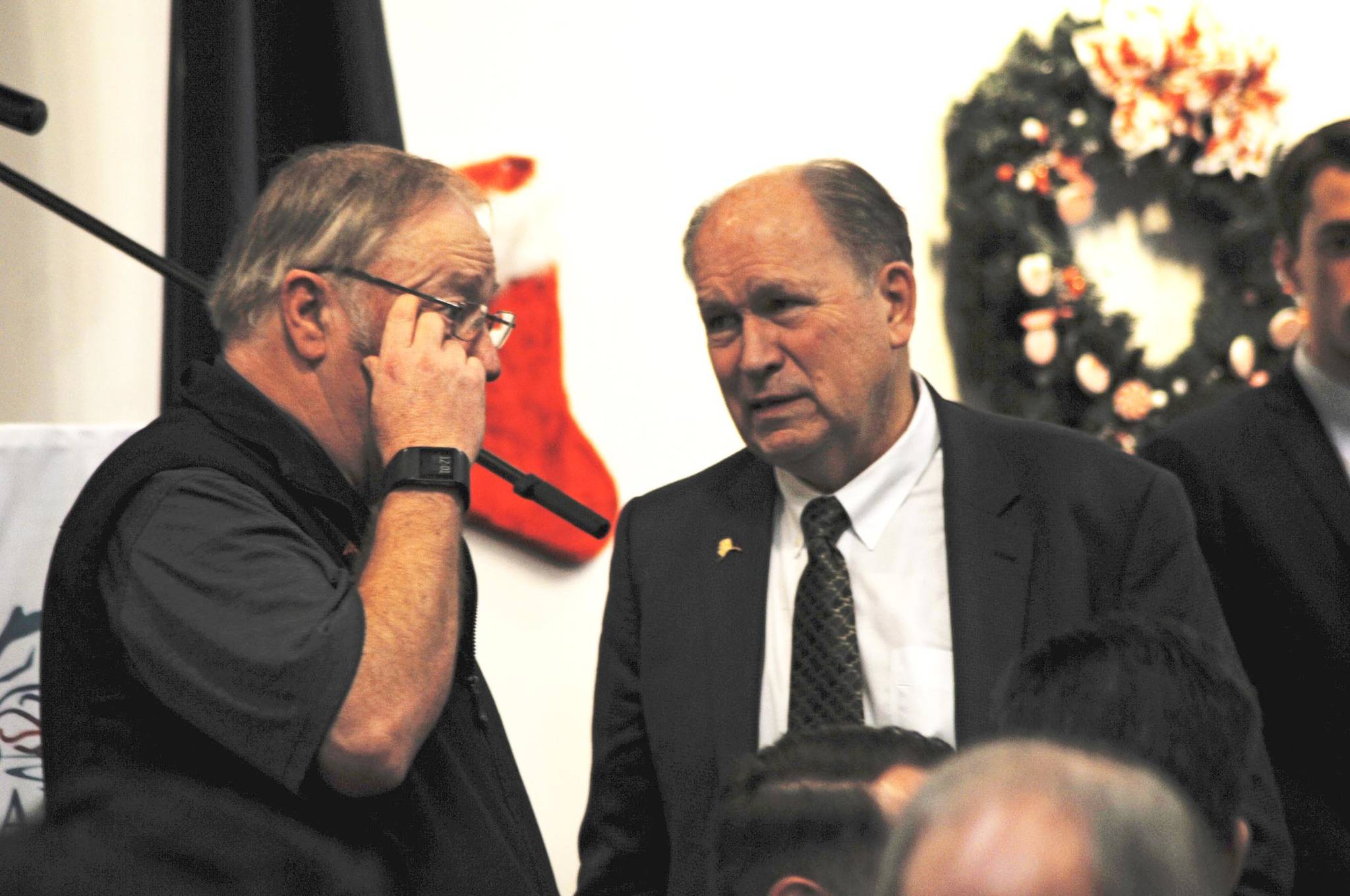 Gov. Bill Walker (right) speaks to Rep. Mike Chenault (R-Nikiski) before the beginning of a joint luncheon of the Kenai and Soldotna chambers of commerce on Tuesday, Dec. 19, 2017 in Kenai, Alaska. Walker visited Kenai on Tuesday to address the chambers of commerce with updates about the Alaska LNG Project. (Photo by Elizabeth Earl/Peninsula Clarion)