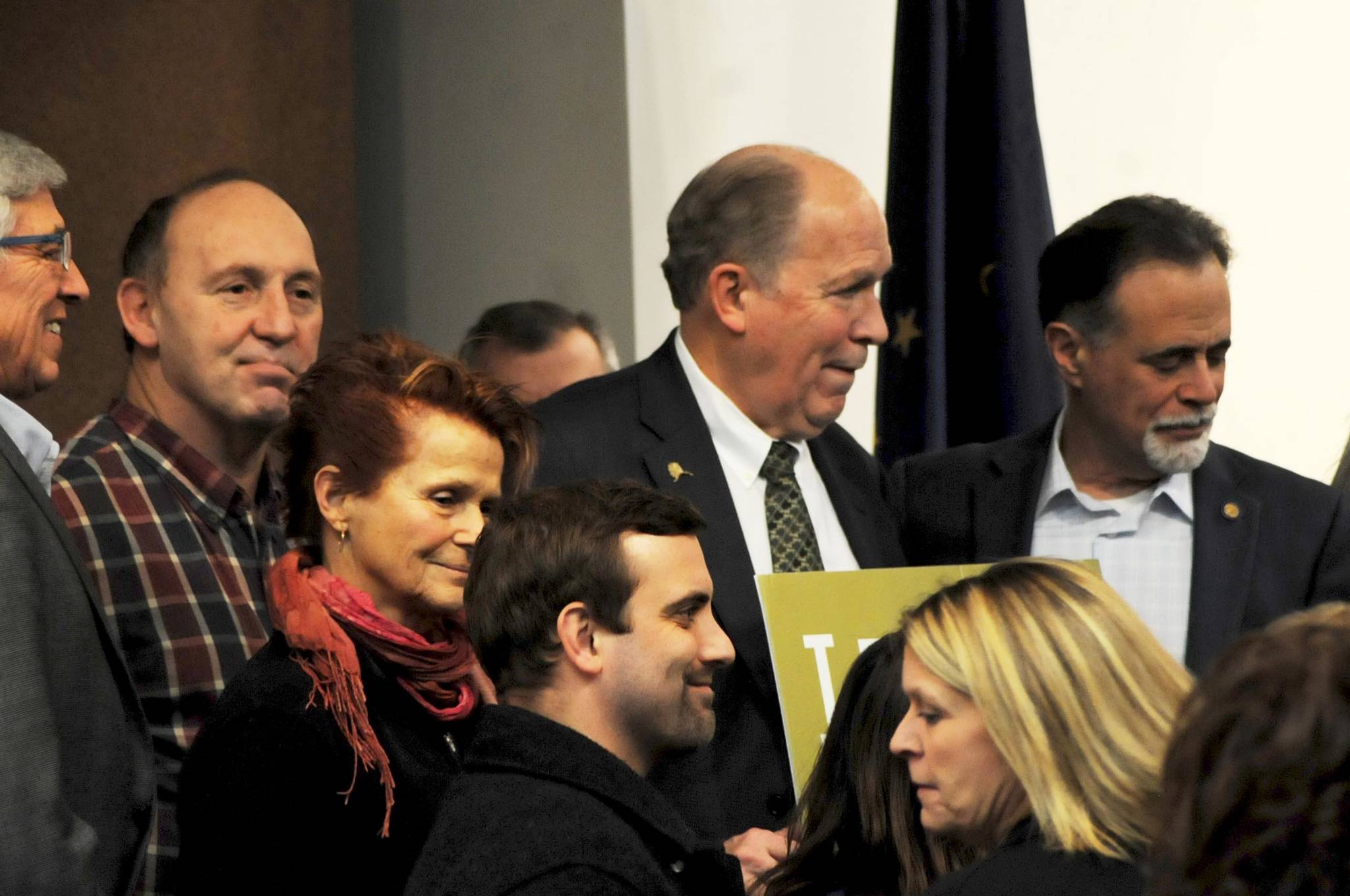 Gov. Bill Walker (center), Sen. Peter Micciche, R-Soldotna, (right) and Rep. Gary Knopp, R-Kenai, (left) stand among a group of citizens and government officials after the conclusion of a joint luncheon of the Kenai and Soldotna chambers of commerce Tuesday, Dec. 19, 2017 in Kenai, Alaska. Walker visited Kenai to address the chambers of commerce with updates on the Alaska LNG Project. (Photo by Elizabeth Earl/Peninsula Clarion)