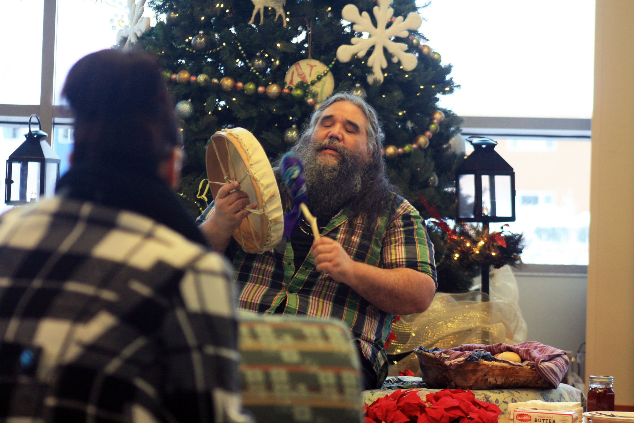 A woman listens to local musician George Demientieff Holly during a Dec. 21 winter solstice performance at Dena’ina Wellness Center in downtown Kenai. (Photo by Erin Thompson/Peninsula Clarion)