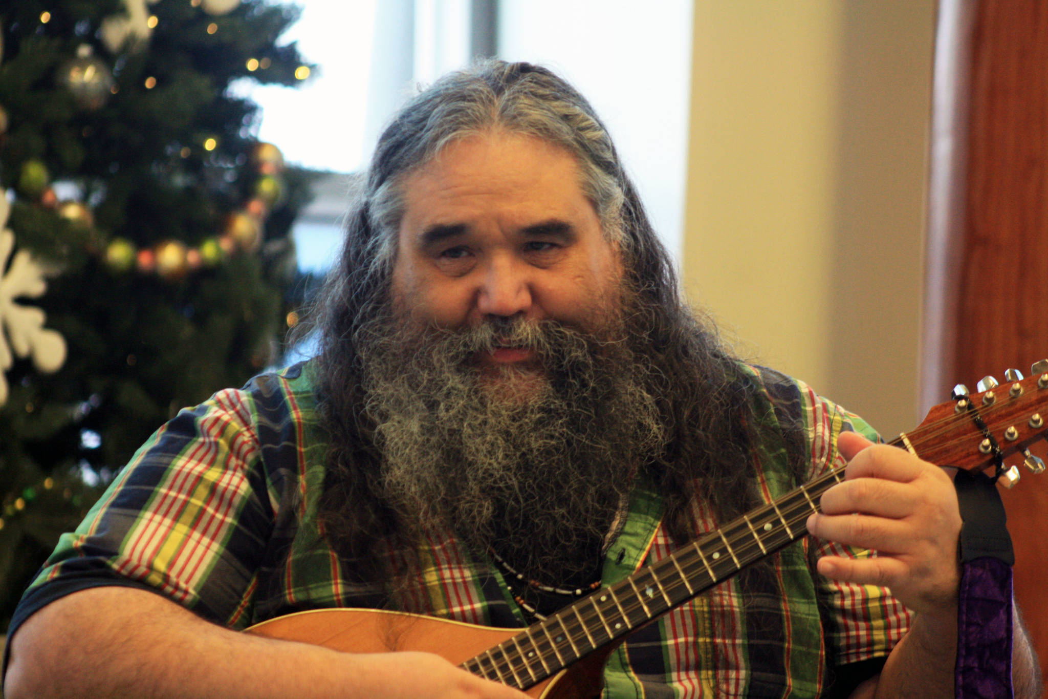 Local musician George Demientieff Holly sings and plays mandolin during a Dec. 21 winter solstice performance at Dena’ina Wellness Center in downtown Kenai. (Photo by Erin Thompson/Peninsula Clarion)