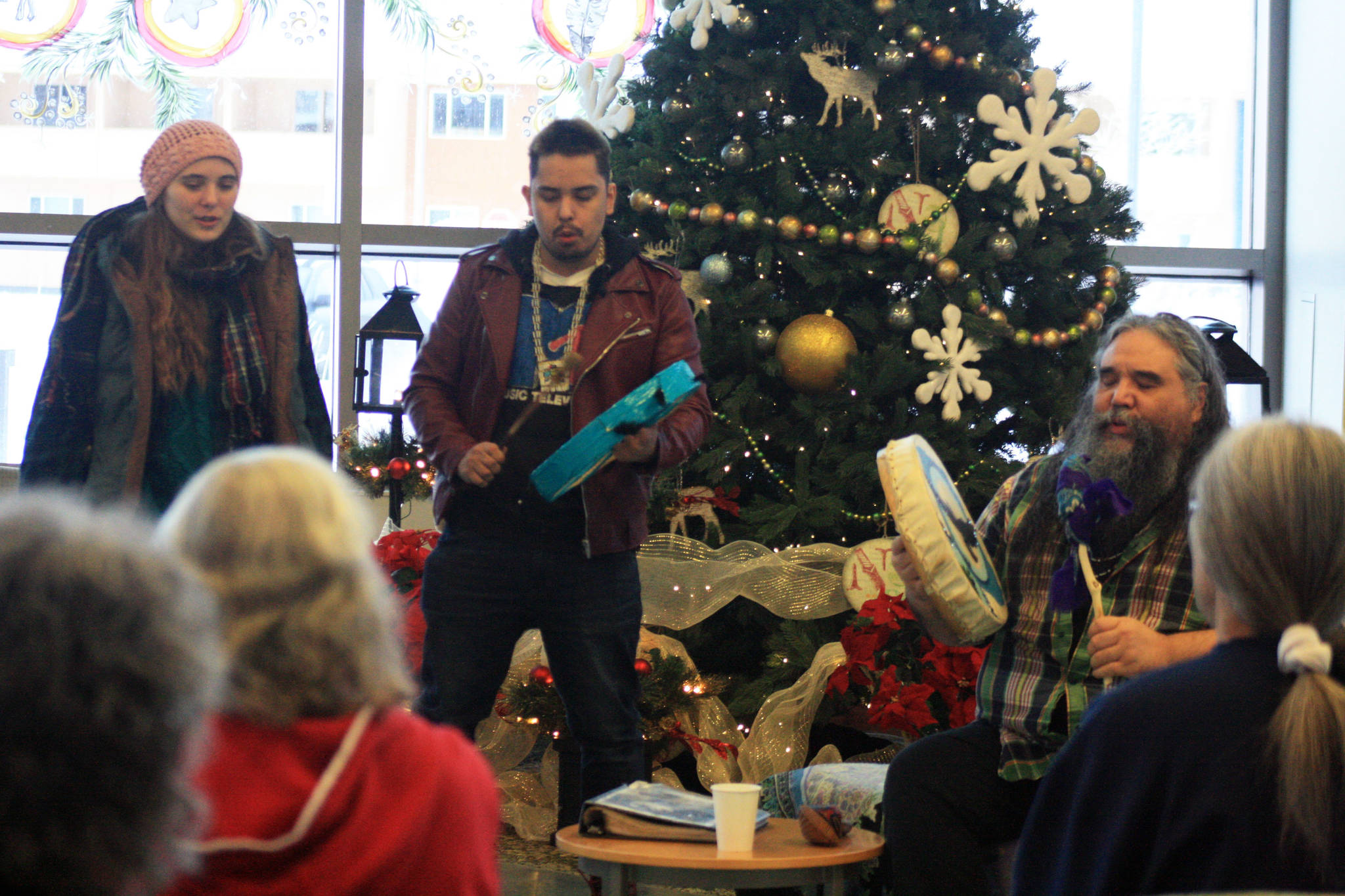 Jasmine Koster and Jimmy Starkloff perform alongside local musician George Demientieff Holly (right) during a Dec. 21 winter solstice performance at Dena’ina Wellness Center in Old Town Kenai. (Photo by Erin Thompson/Peninsula Clarion)