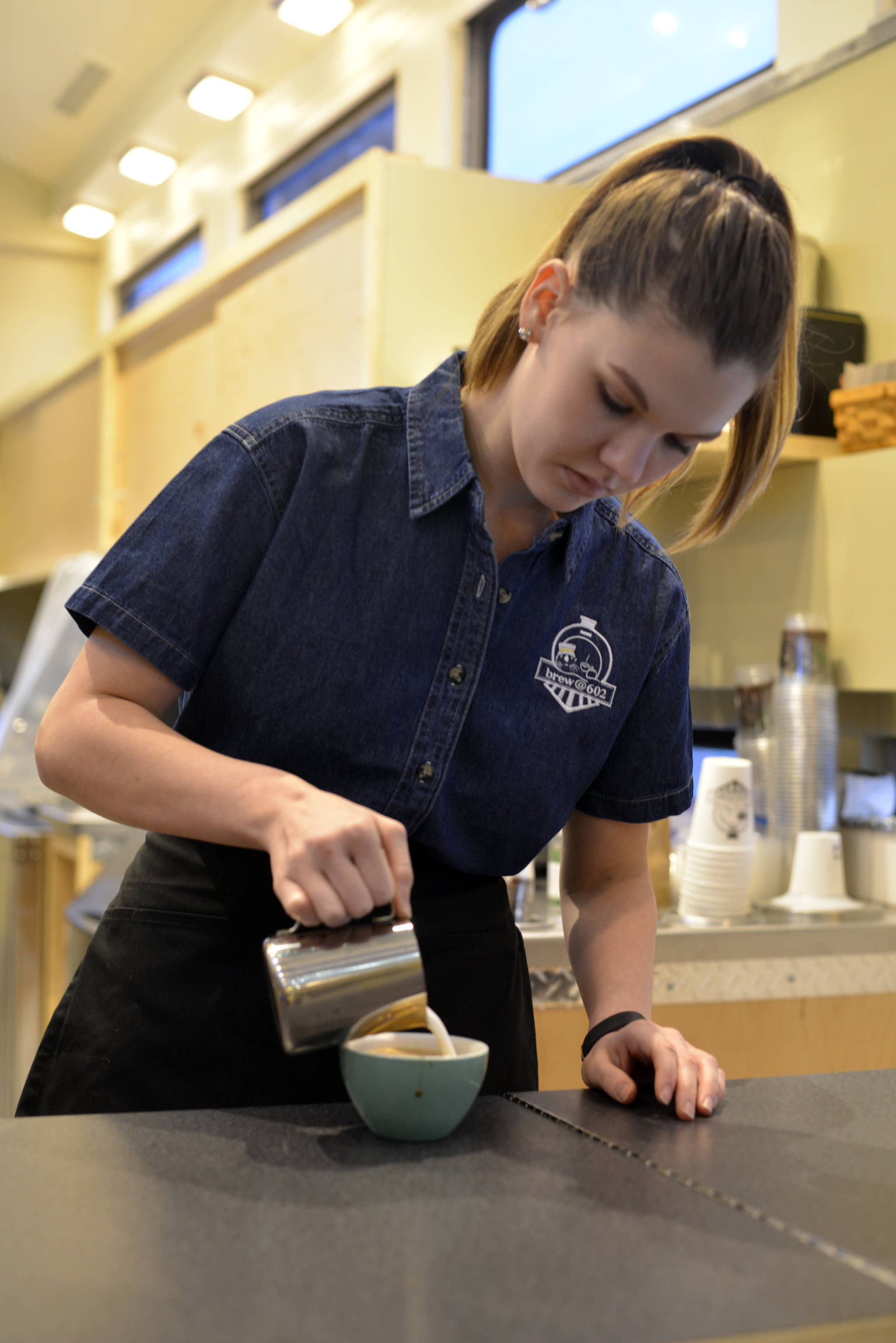 Alyeska Krull puts the finishing touches on a coffee drink during the final days of training before the grand opening of Brew@602, a coffee and waffle shop located on Kleeb Loop Road. The shop will be serving Steam Dot coffee from Anchorage. (Photo by Kat Sorensen/Peninsula Clarion)