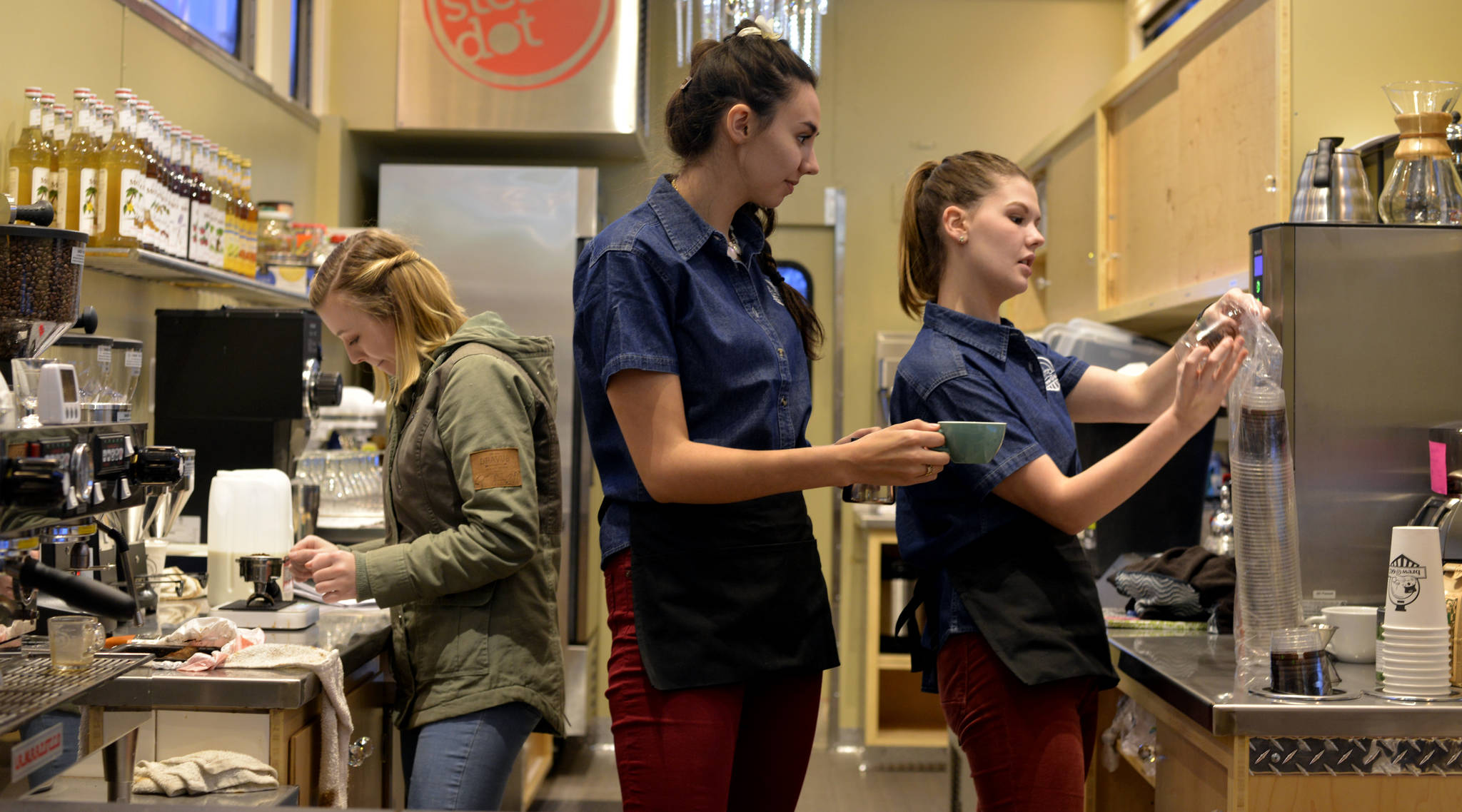 Melia Harding, from left, Elan Krull and Alyeska Krull work through a typical order while training for the grand opening of Brew@602 on Kleeb Loop Road, a coffee and waffle shop located inside a double decker rail car. (Photo by Kat Sorensen/Peninsula Clarion)
