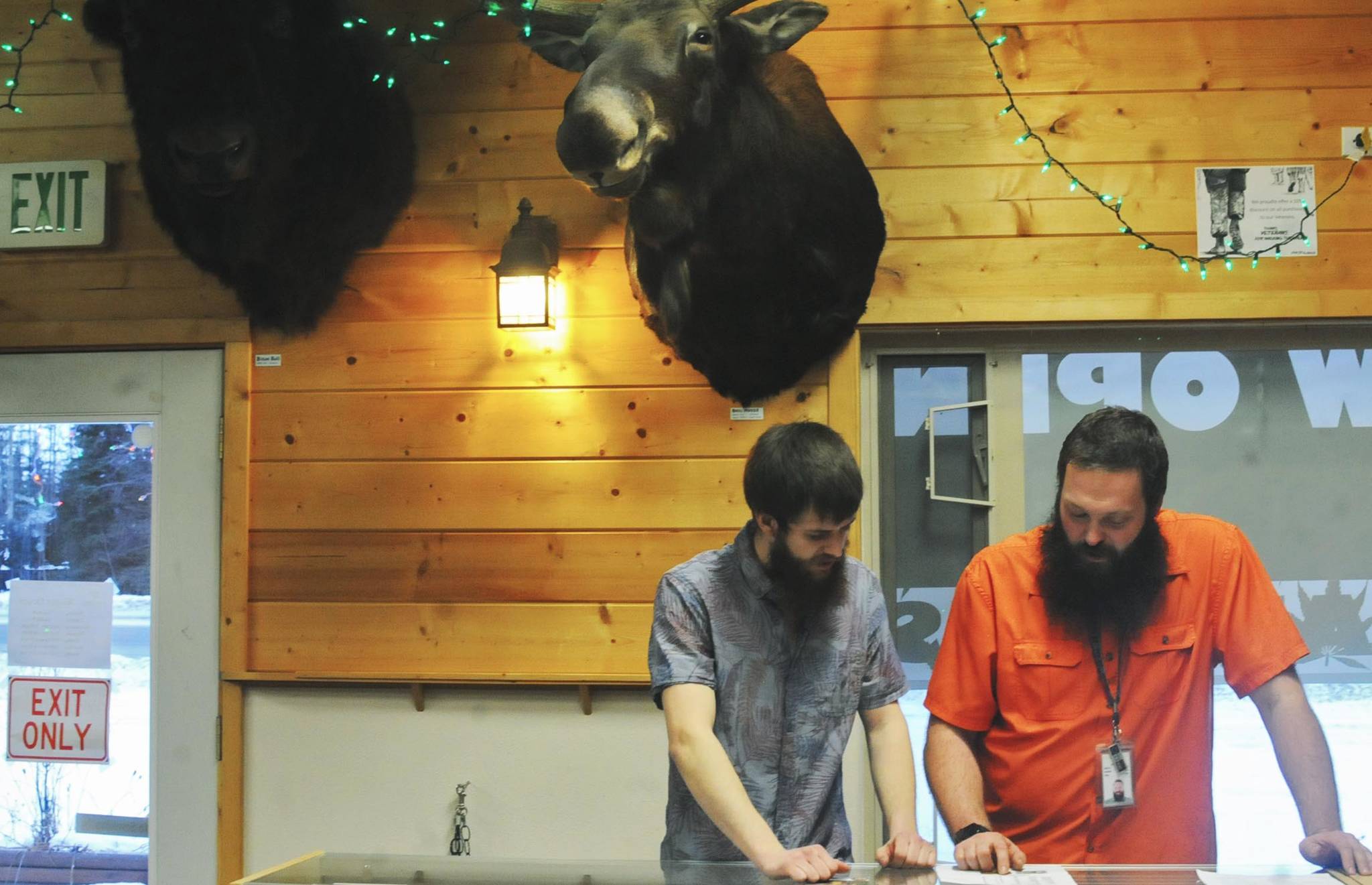 Dylan Griffith (left) and Chase Griffith (right), co-owners of cannabis retailer and cultivator Permafrost Distributors, talk behind the counter at their Sterling Highway store on Sunday, Dec. 10, 2017 in Sterling, Alaska. The brothers opened their Nikiski limited cultivation operation in December 2016 and expanded to the Sterling retail store and cultivation operation in June 2017. (Photo by Elizabeth Earl/Peninsula Clarion)