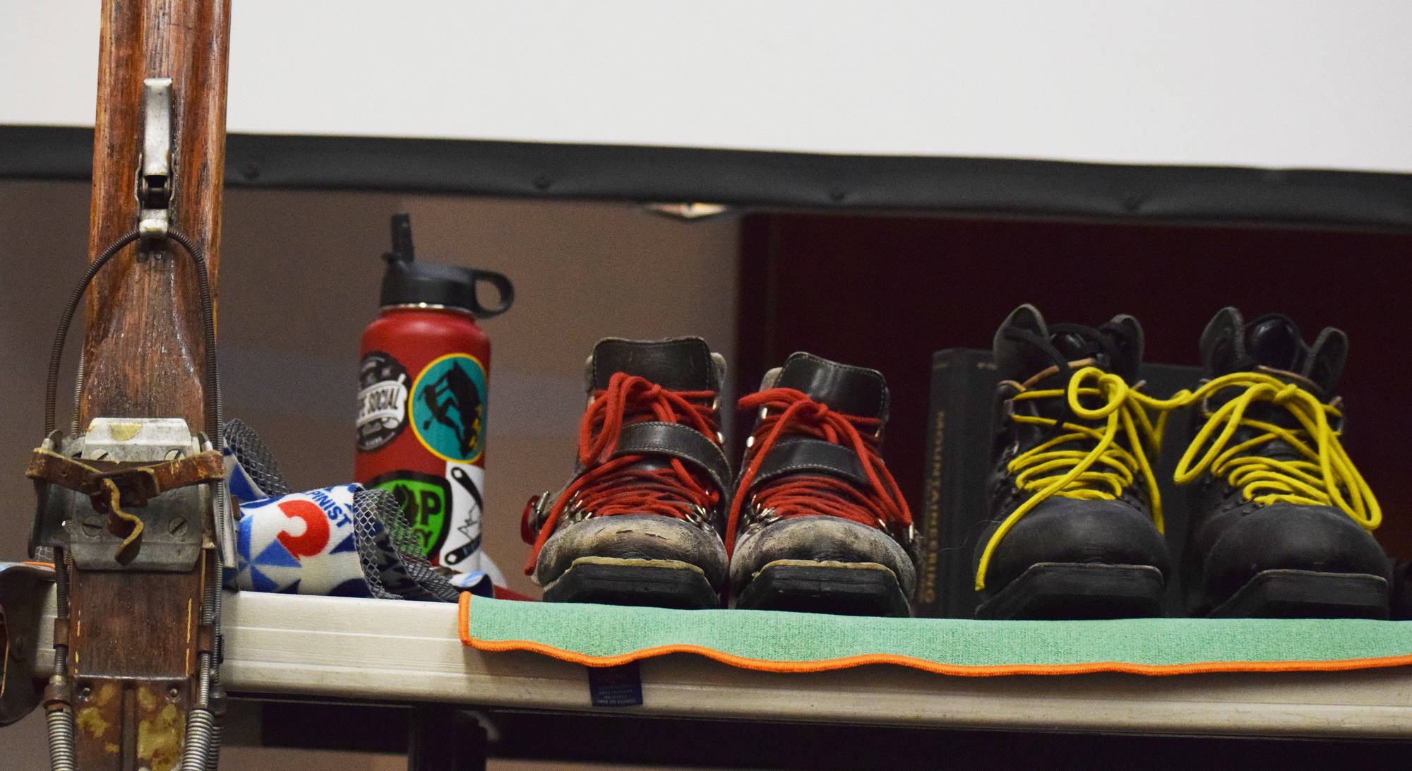Ski boots line a table during a backcountry skiing presentation by Tony Doyle and Trent Sexton, Dec. 20 at the Kenai Visitors and Cultural Center. (Photo by Joey Klecka/Peninsula Clarion)